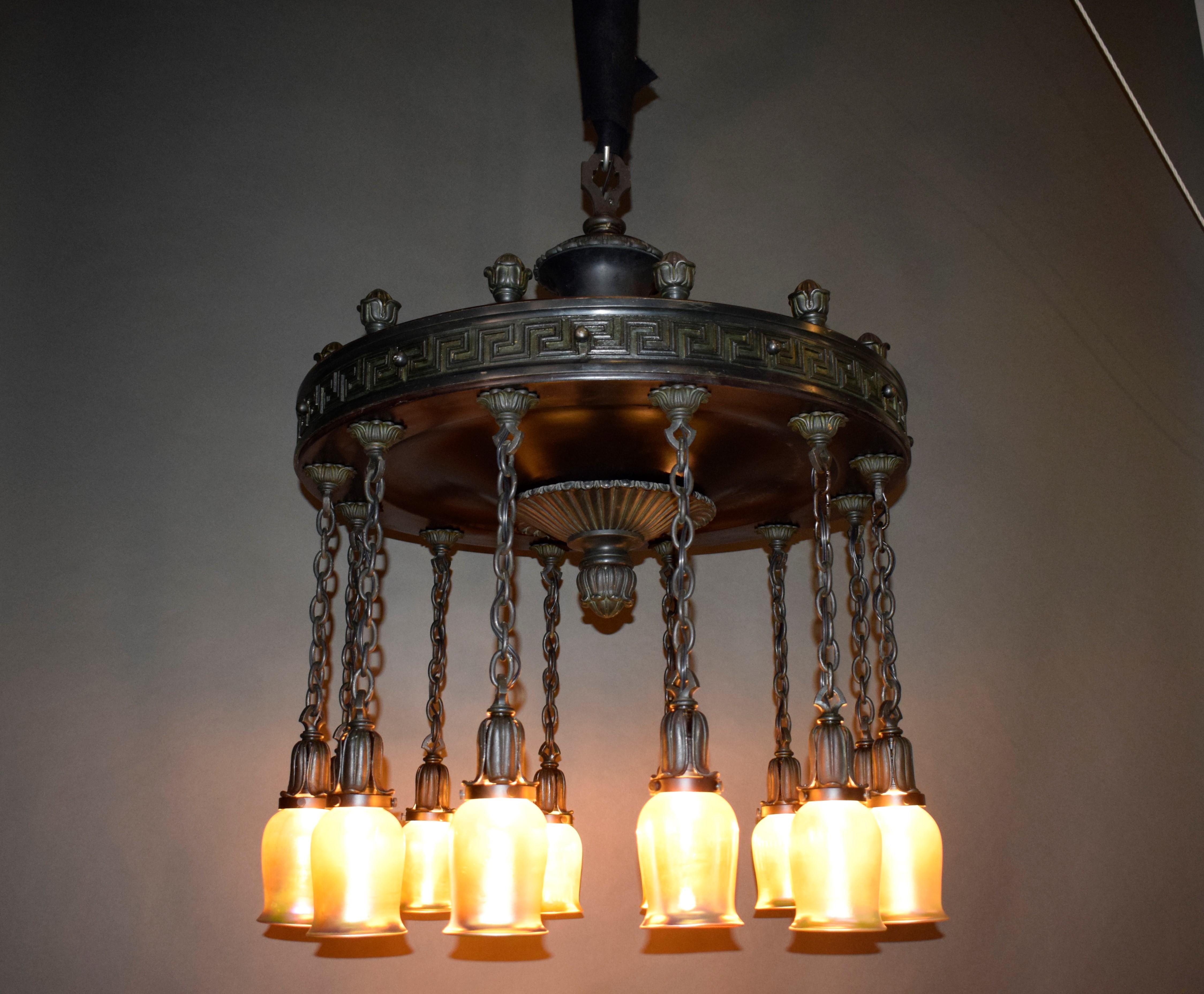 A magnificent Art Nouveau style chandelier with Greek key. Patinated bronze featuring twelve iridescent shades (unmarked). Circa 1920.
CW5150