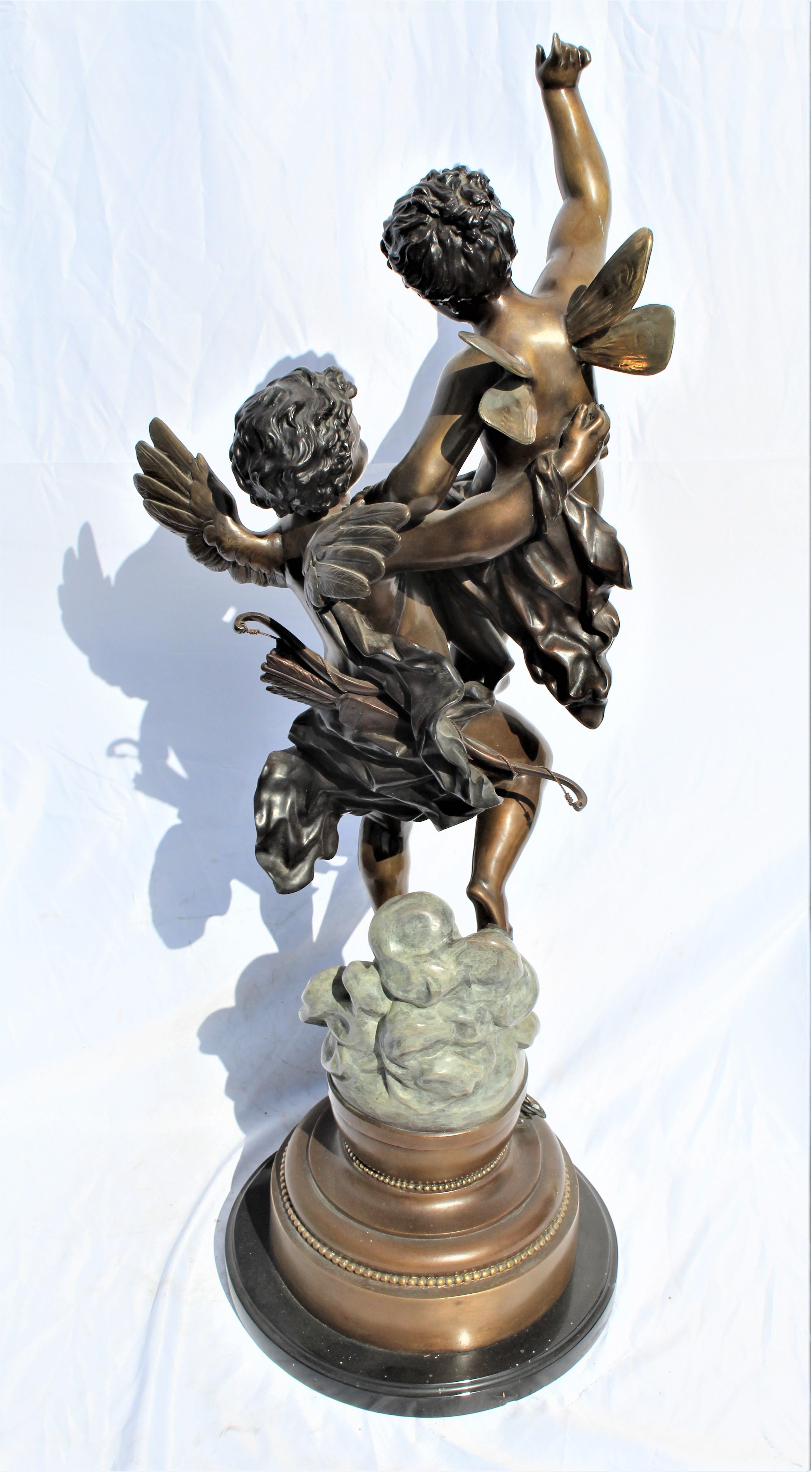 Great looking large bronze sculpture of winged pixy held by a Cherub floating on the clouds. Multi-patinas with fine details. Made from the original. Bears the signature at base. The title is the Triumphator.