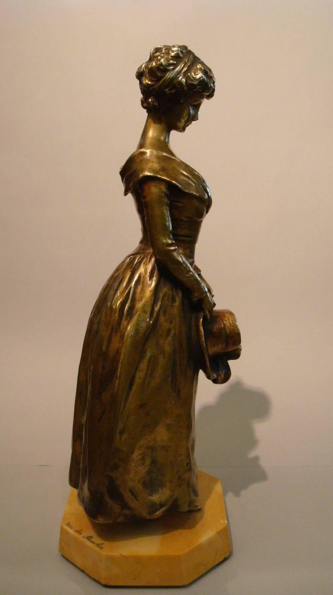 Bronzo della fine del XIX secolo dello scultore belga Georges Van der Straeten (1856-1941) che raffigura un'elegante fanciulla in piedi con un cappello sulle mani. Firmato Van der Straeten sulla base e numerato sotto la figura.  Sigillo