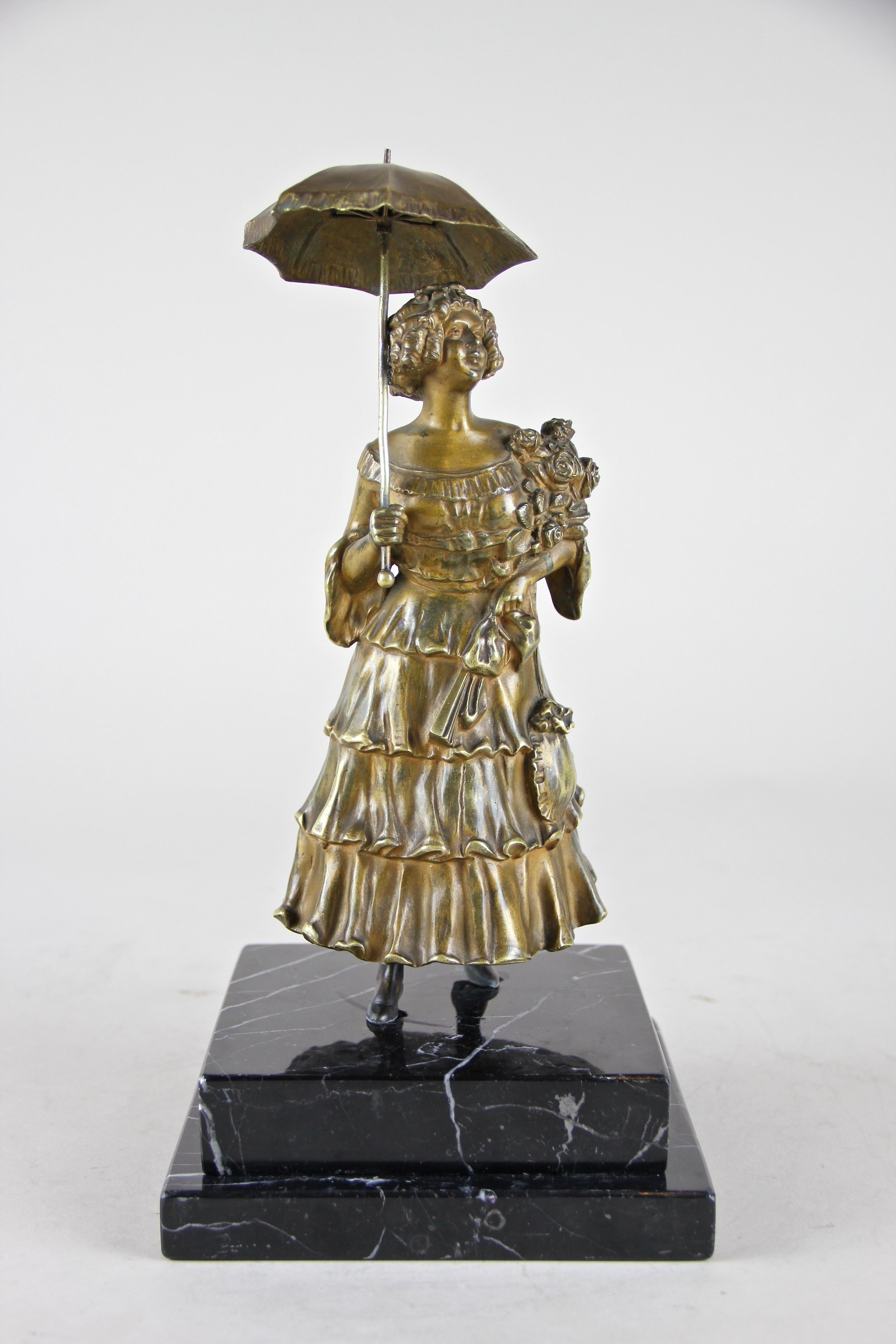 Lovely bronze figurine attributed to Carl Kauba (1865 - 1922) from the early Art Nouveau period in Austria, circa 1900. The small but heavy solid bronze sculpture stands on a base of black marble depicting a beautiful young lady in a traditional