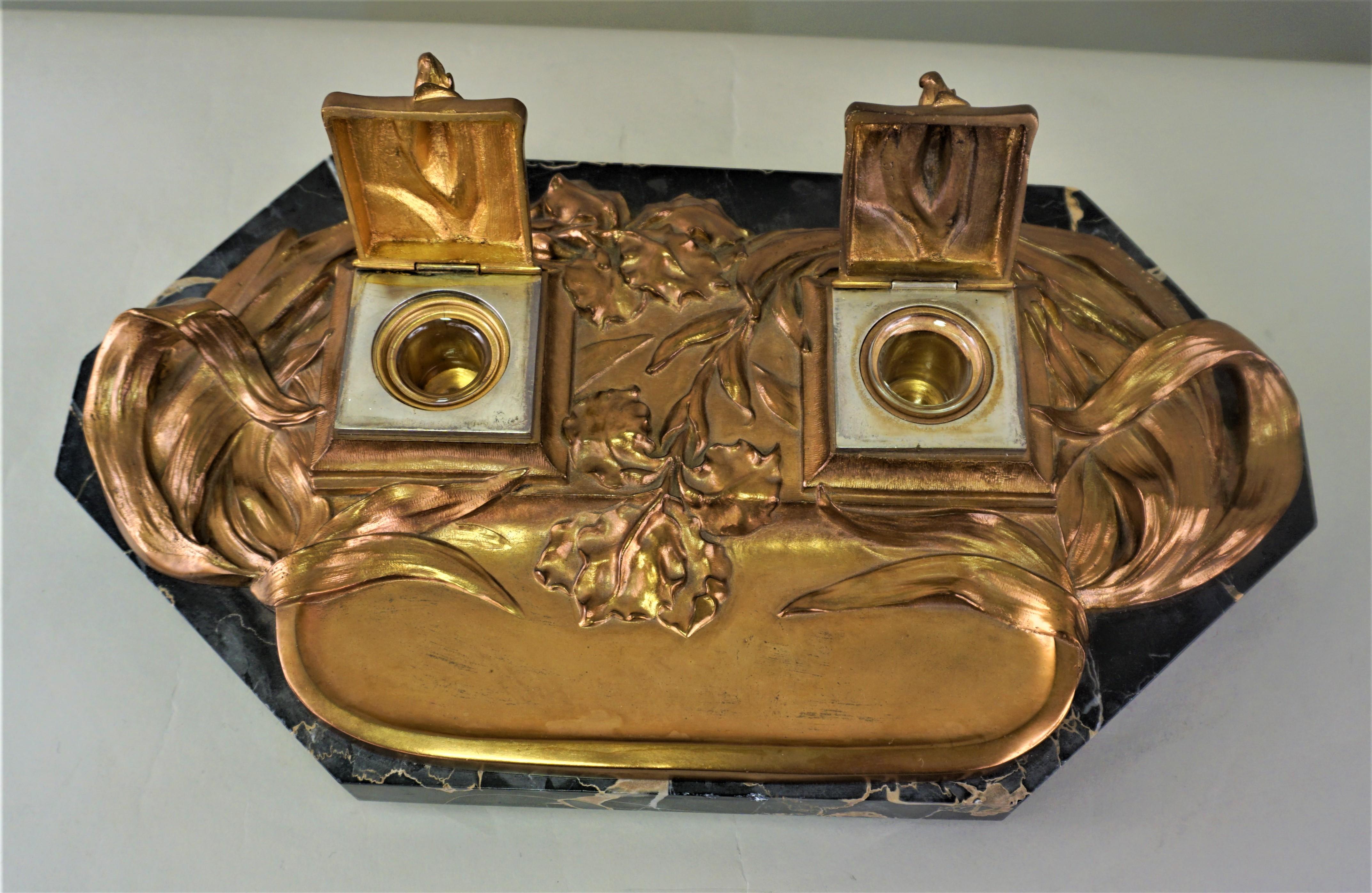 An amazing work, double inkwells in red coopery color bronze with flower and leaf accents and marble base.