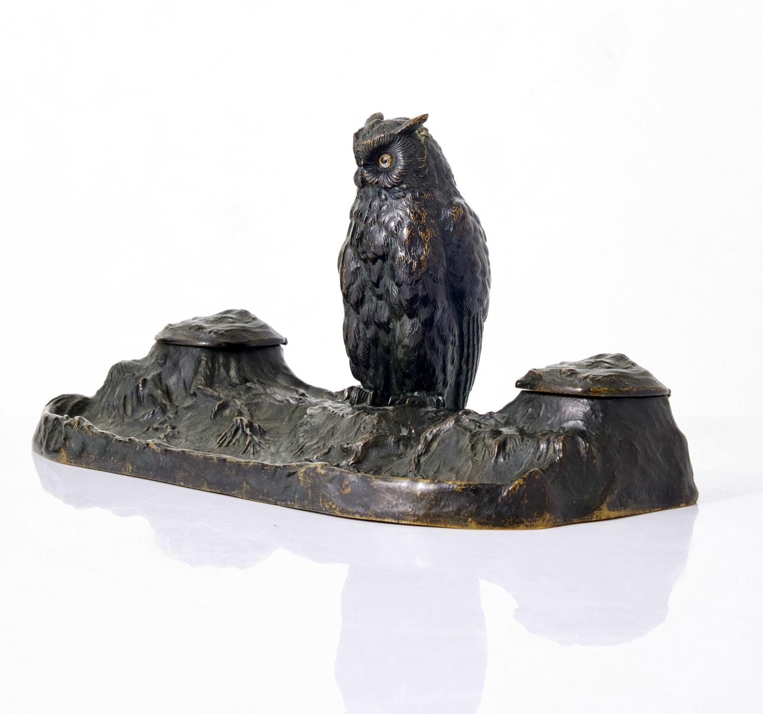 An Art Noveau or Jugend patinated bronze pen and inkwell with an owl sitting in the center. The owl have inset glass eyes. Made ca.1900. Possibly Swedish. 
Symbolism of the owl: The modern West generally associates owls with wisdom and vigilance.