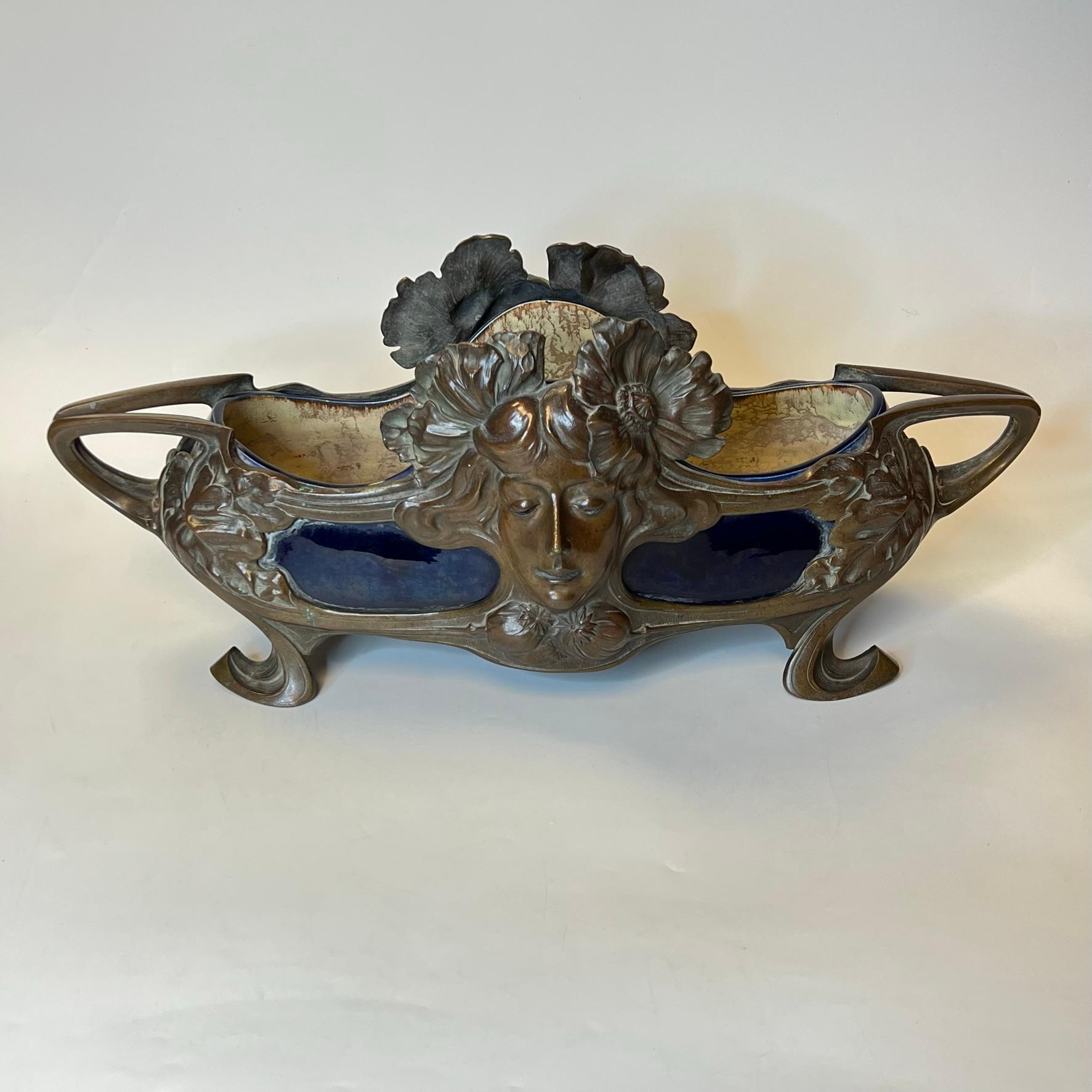 Antique French bronze jardiniere with blue glazed ceramic insert with the prominent face of a lovely female on each side.  In very good condition.  Apparently unsigned.
