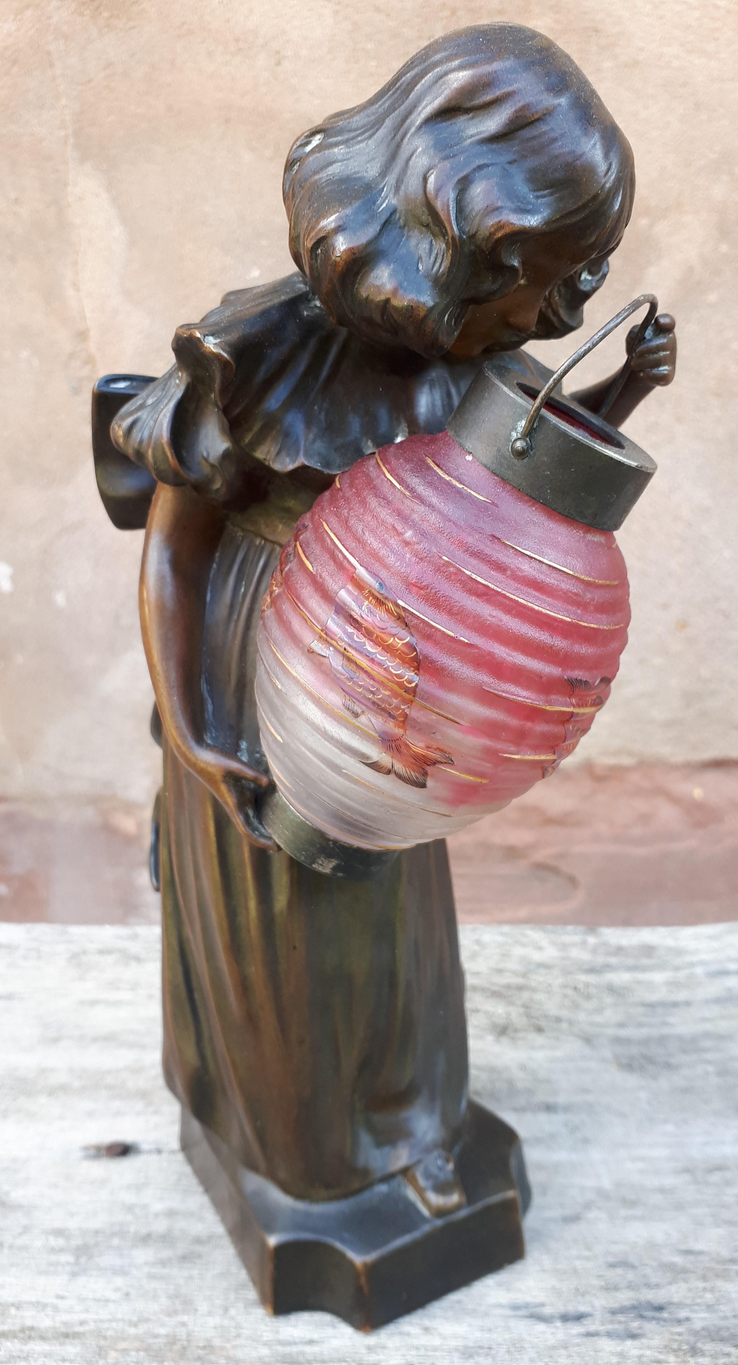 Rare lamp in bronze and glass paste resulting from a collaboration between two prestigious names from the Art Nouveau period, Laporte Blairsy and Daum, representing a little girl looking into the bottom of a lantern.
The bronze is numbered 