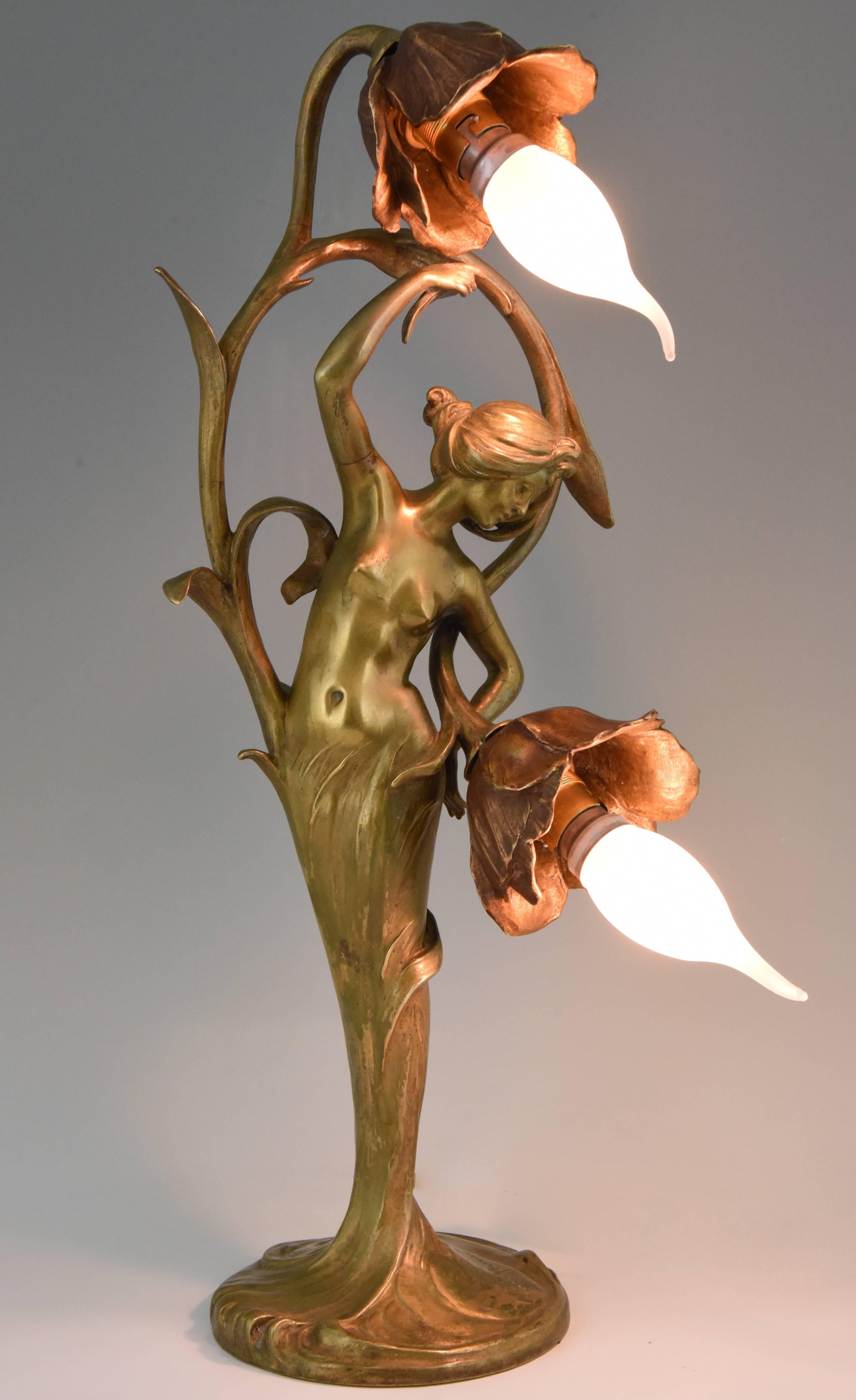 Belle lampe Art Nouveau en bronze avec une dame semi-nue tenant deux fleurs, signée par les frères français Louis et François Moreau, vers 1900.