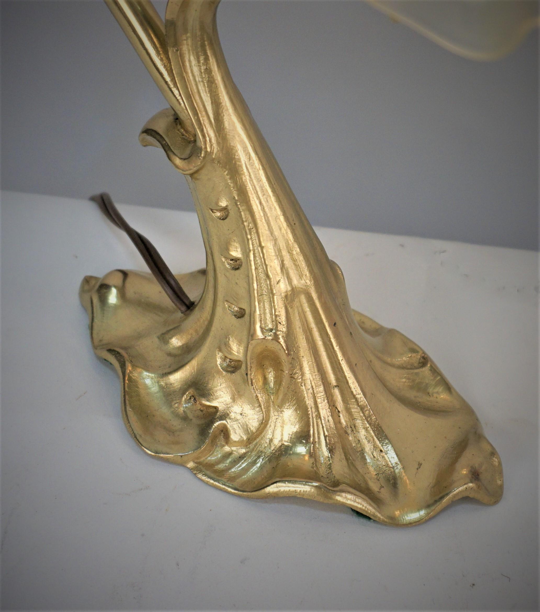 An art nouveau bronze adjustable neck desk or table lamp with beautiful opaline glass shade.