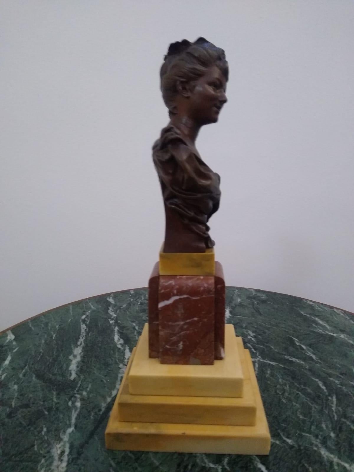 A charming bust of a young lady , it is executed in the lost-wax method in a single piece mounted on a base of different tones of marbles.  The surface is finished in reddish-oxide toned patina. 
Casting from the first quarter of the 20th century.