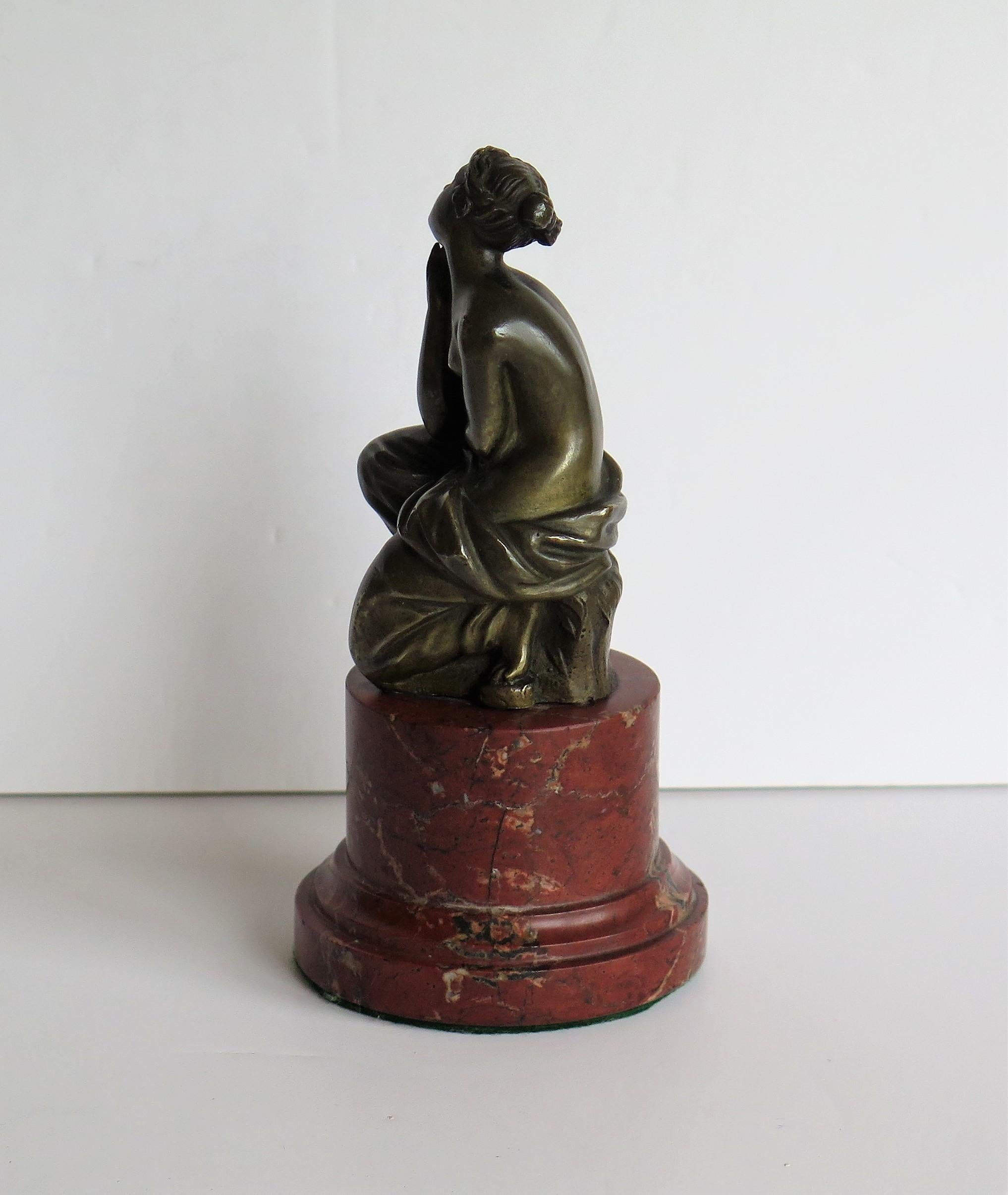 This is a solid bronze figurine sculpture of a seated lady on a good red marble base, in the art-nouveau style and dating to the 19th century, probably by a French or Austrian maker.

The bronze figure is beautifully sculpted in very good clear
