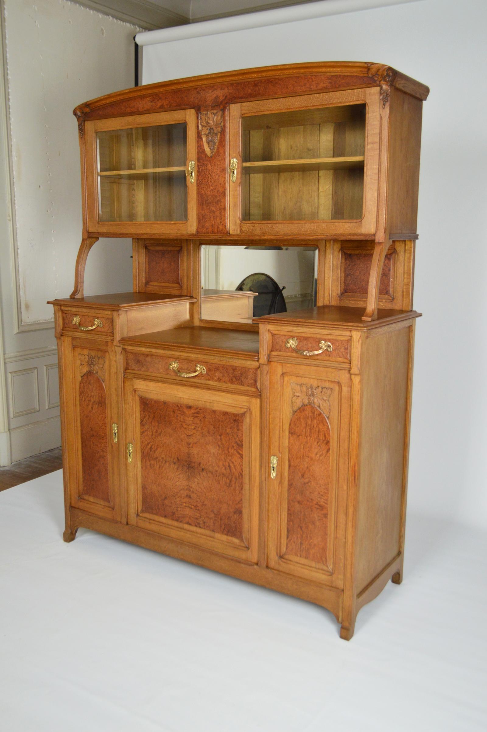 Buffet/cabinet in carved oak and elm burl.
Art Nouveau / Ecole de Nancy, France, circa 1910.
Unsigned, in the style of Majorelle, Gauthier-Poinsignon, Diot. 
In good condition. 

The bronzes (entries of locks and handles) and the sculptures of