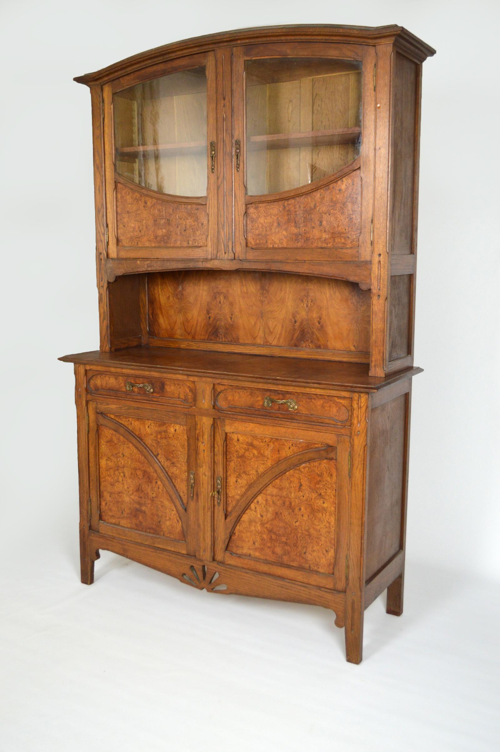 Buffet/cabinet in carved oak and elm burl.
Art Nouveau / Arts & Crafts, France, circa 1910.
In good condition.

The bronzes (entries of locks and handles) are on the theme of the quince / Cydonia (fruits & leaves). 

Two parts buffet:
Lower