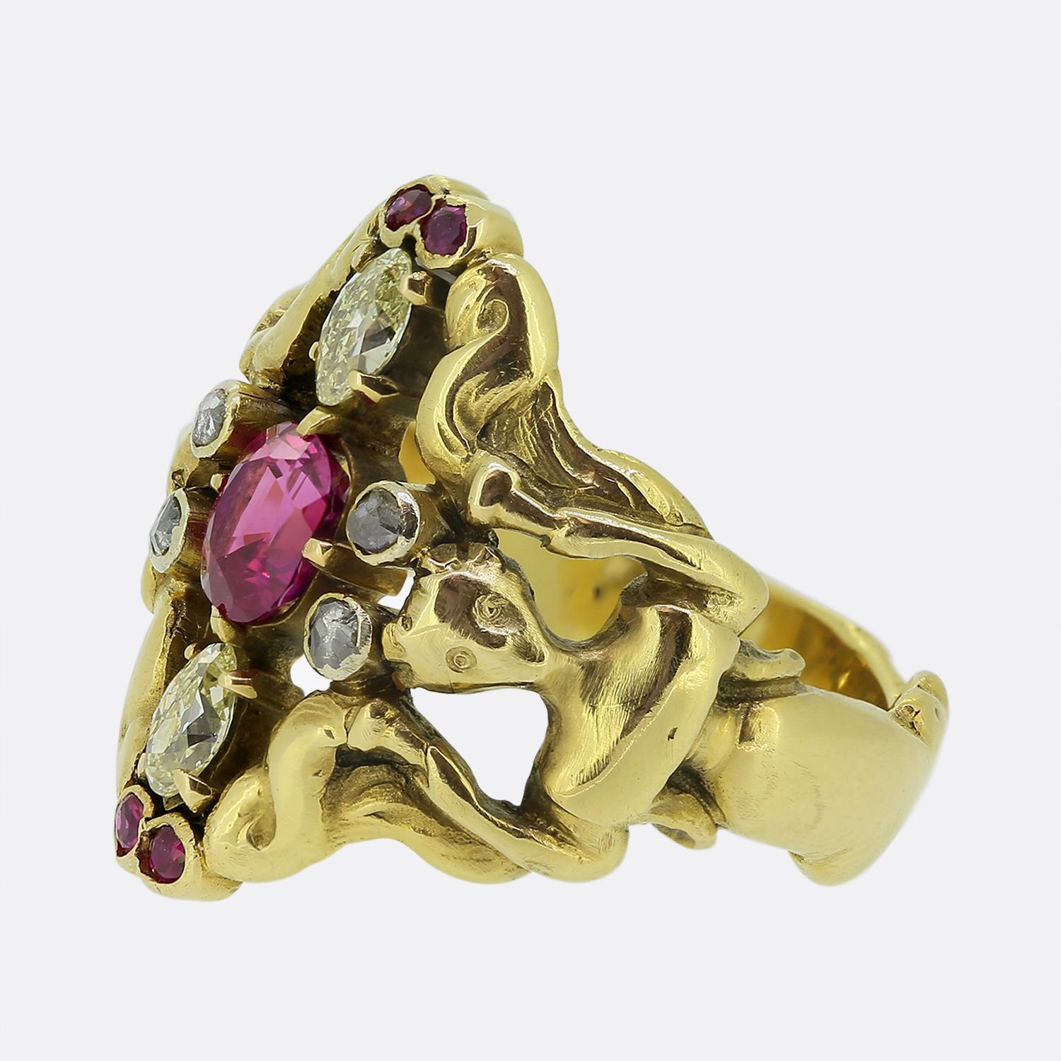 Here we have an intricately designed 18ct yellow gold ring taken from the Art Nouveau movement. This piece features a centralised pinky red ruby of Burmese origin accompanied by a fancy yellow marquise cut diamond above and below. The design