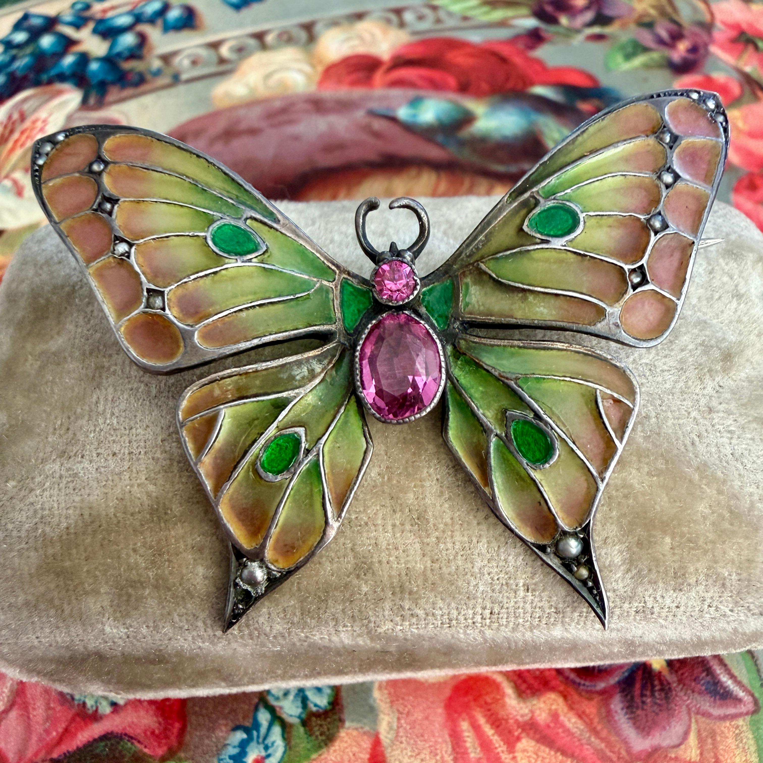 Details:
Art Nouveau Butterfly Brooch Plique-a-Jour in sterling silver in beautiful shades of pinks, peaches and green. The body of the Butterfly is made up of two vibrant pink turmalines, and the little dotted details are tiny sweet pearls. The