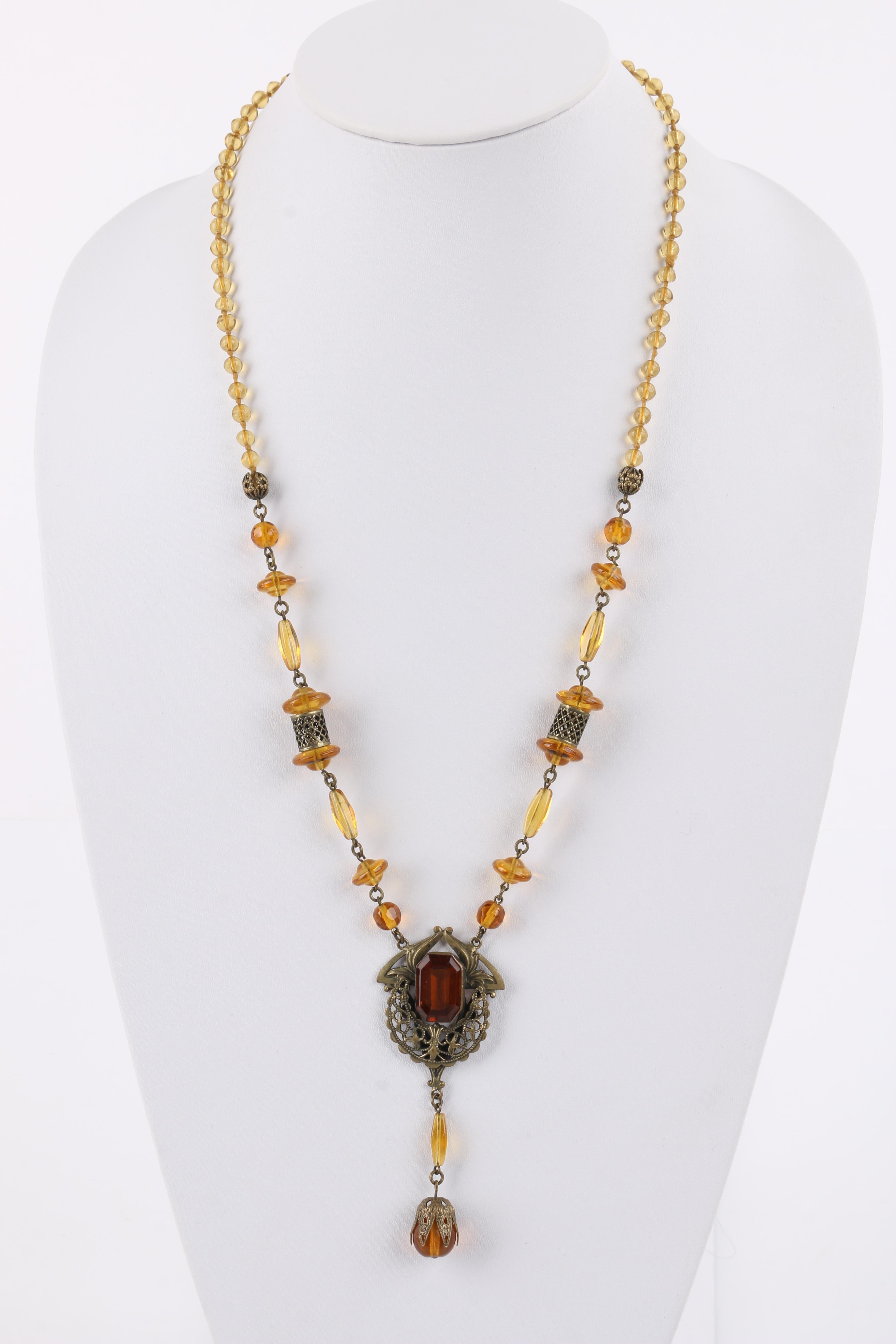 DESCRIPTION: ART NOUVEAU c.1920's Ornamental Brass Amber Czech Glass Beaded Pendant Necklace
 
Circa: c.1920’s
Markings: None
Style: Pendant necklace
Color(s): Amber; Brass
Unmarked Material (feel of): Brass-toned metal; glass
Additional Details /