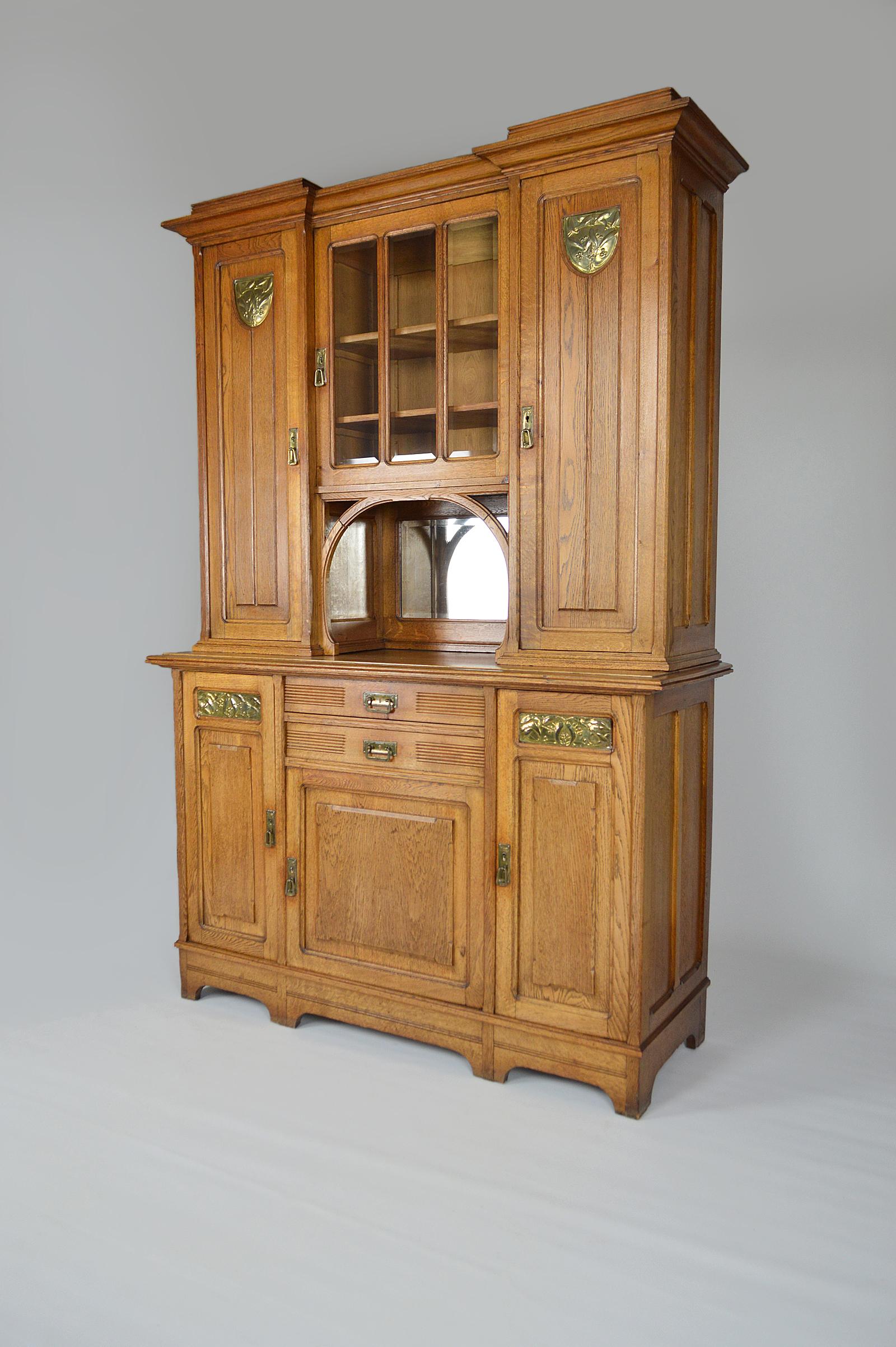 Buffet / china cabinet in solid paneled oak.

Interesting Belgian or French cabinetmaking and brasswork circa 1910-1920, certain influence of Anglo-Saxon Arts & Crafts movements and Dutch Nieuwe Kunst, we are on a piece from the transitional