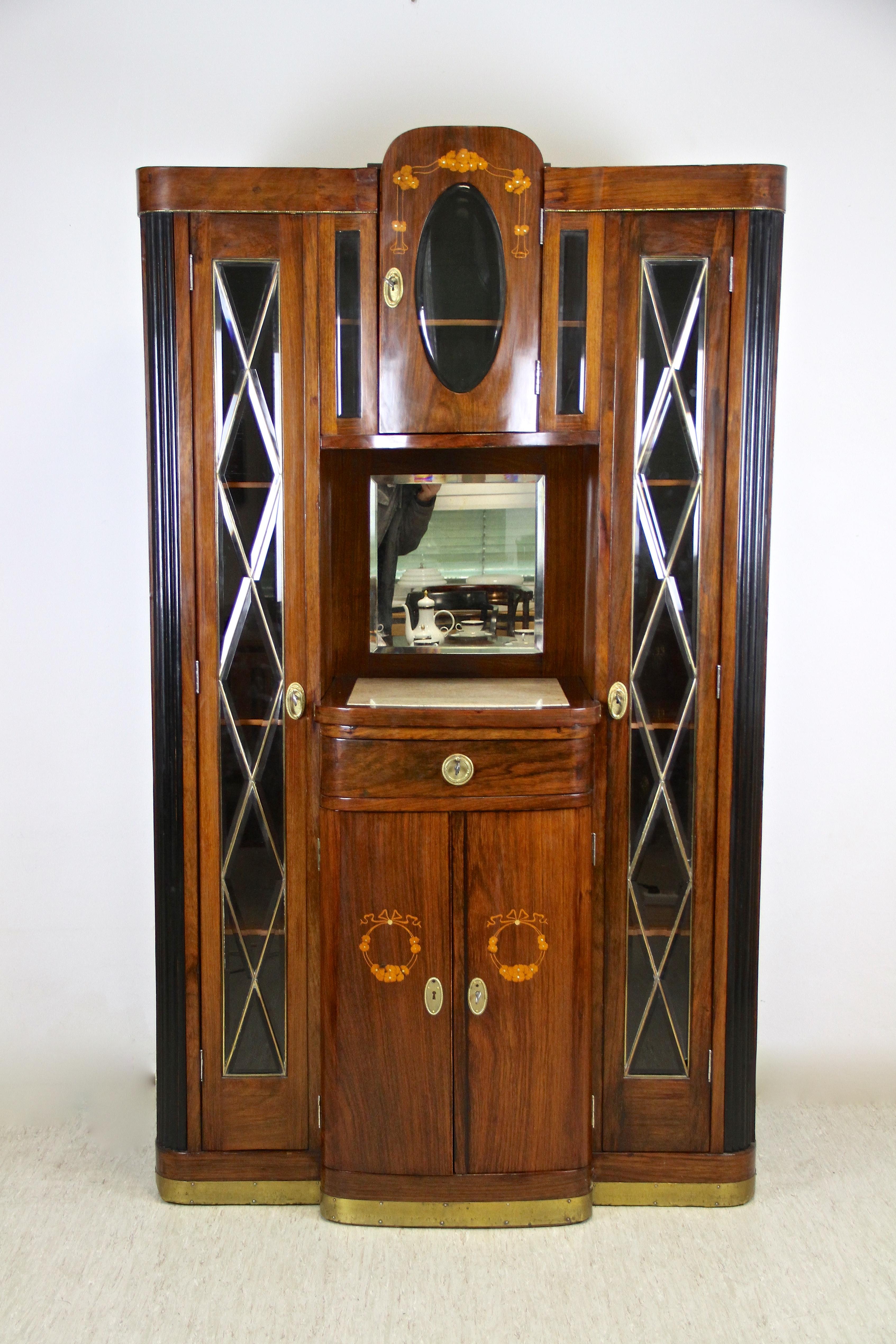 Artfully made Art Nouveau cabinet or buffet from Vienna/ Austria, circa 1910. Beautifully veneered in fine palisander the lower middle part shows a slightly convex shape providing two doors with inlayed flowers, mother of pearl and a drawer. Above