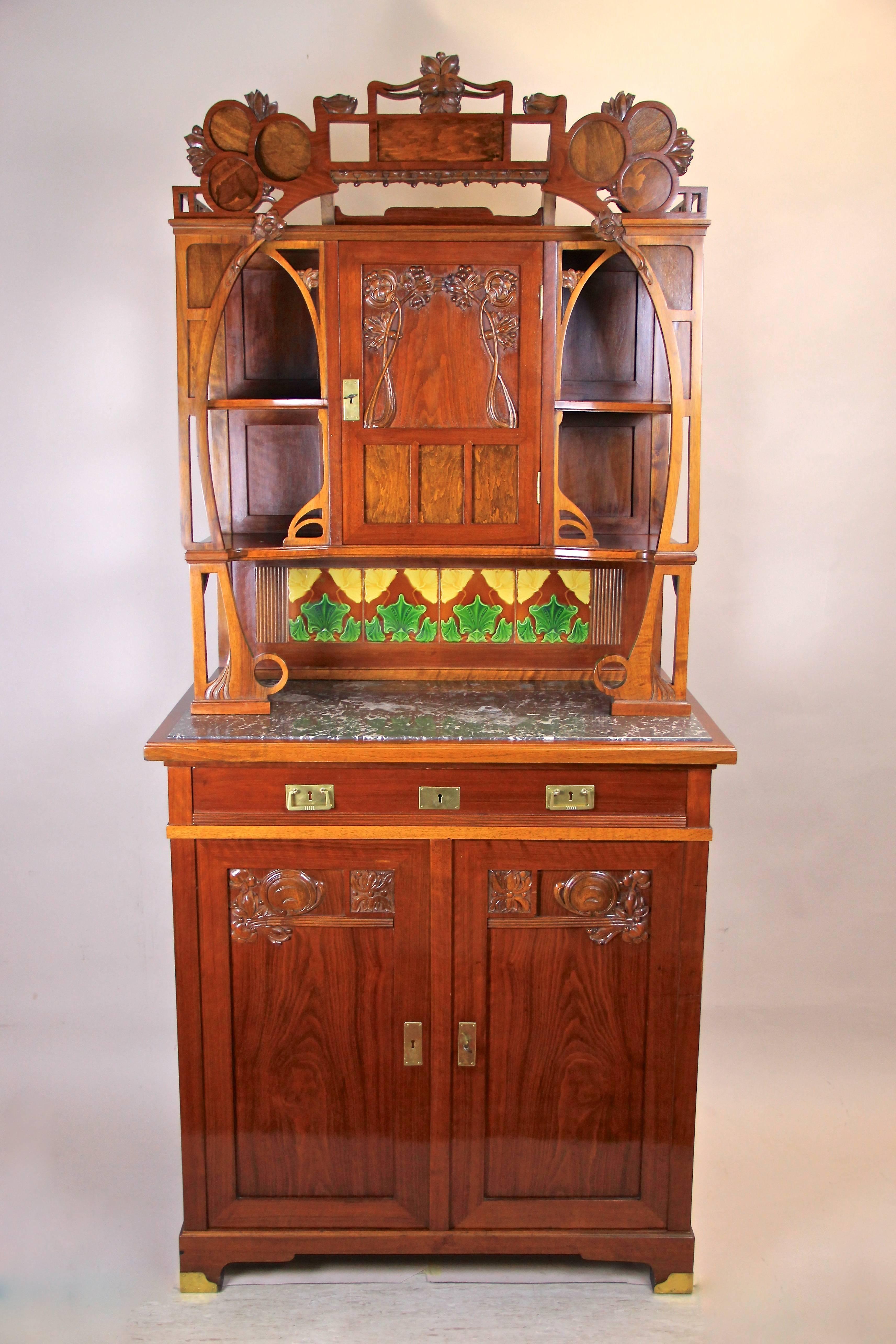 This amazing Art Nouveau cabinet originated from Austria circa 1900 takes up the design language of the Art Nouveau period at its best. It consists of a lower part with a drawer and two doors that shows wonderful hand-carved floral design. An