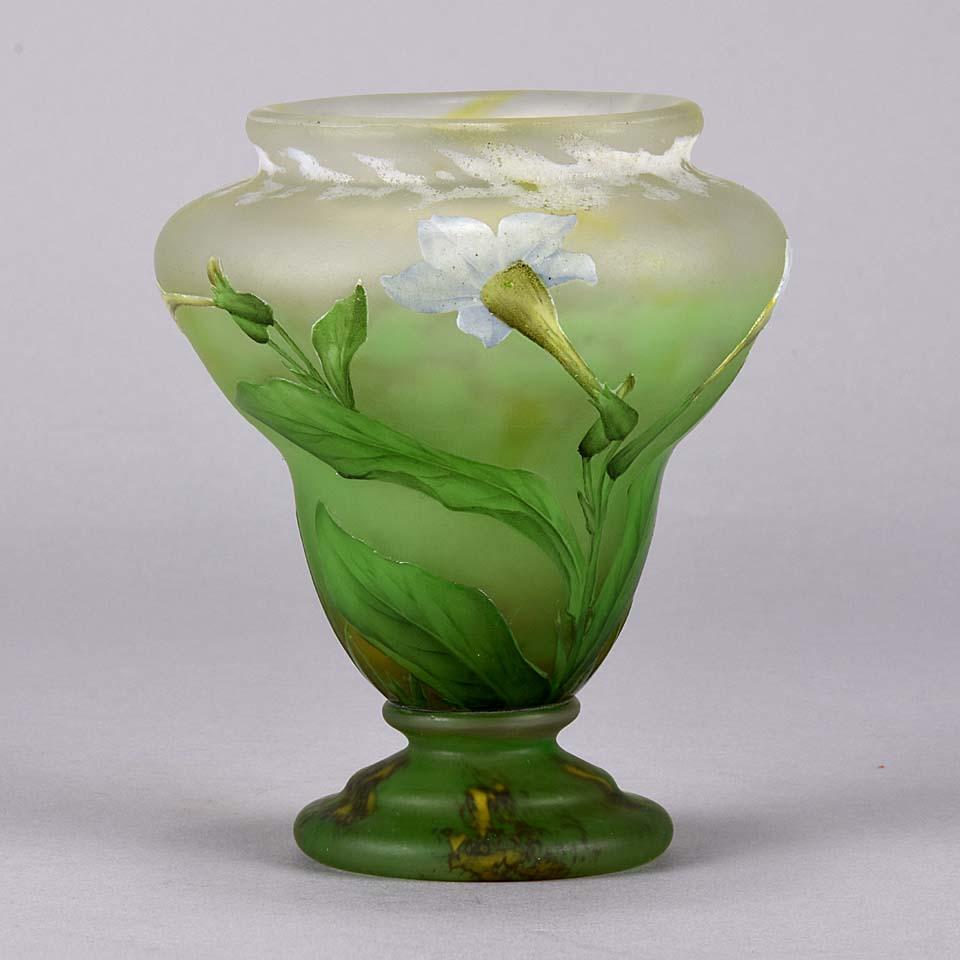 A stunning Art Nouveau cameo glass vase etched and enamelled with white 'Nicotiana alata Grandiflora' flowers against a green field with fabulous colours and fine detail, signed Daum Nancy and with Cross of Lorraine. 
 
Daum Frères (French, late