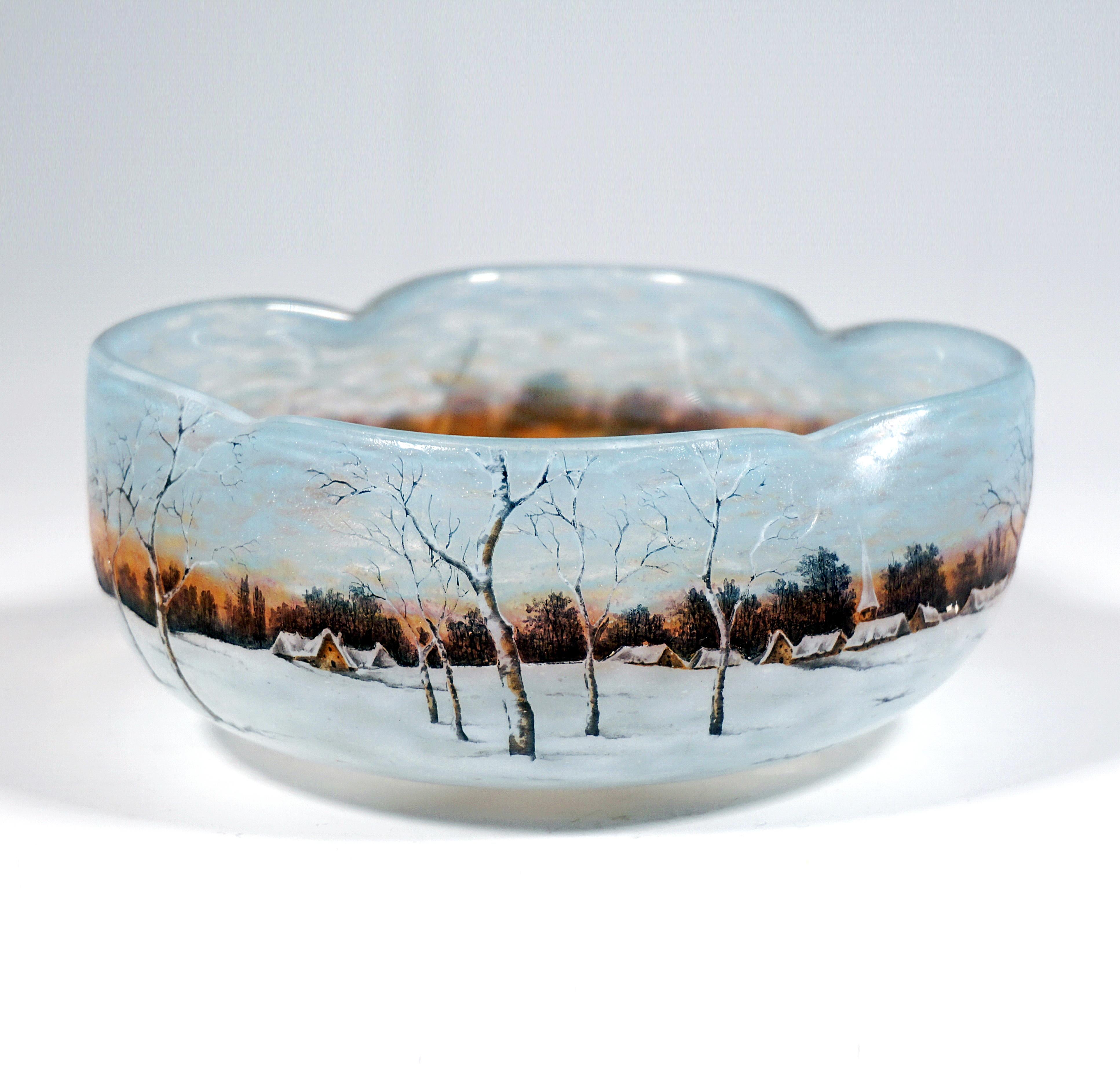 Delicate Nancy art glass from the early French Art Nouveau period:
Round bowl made of colourless glass with a fourfold indented opening, flaky powder meltings in light blue, orange-red and pasty white, highly etched and finely painted winter