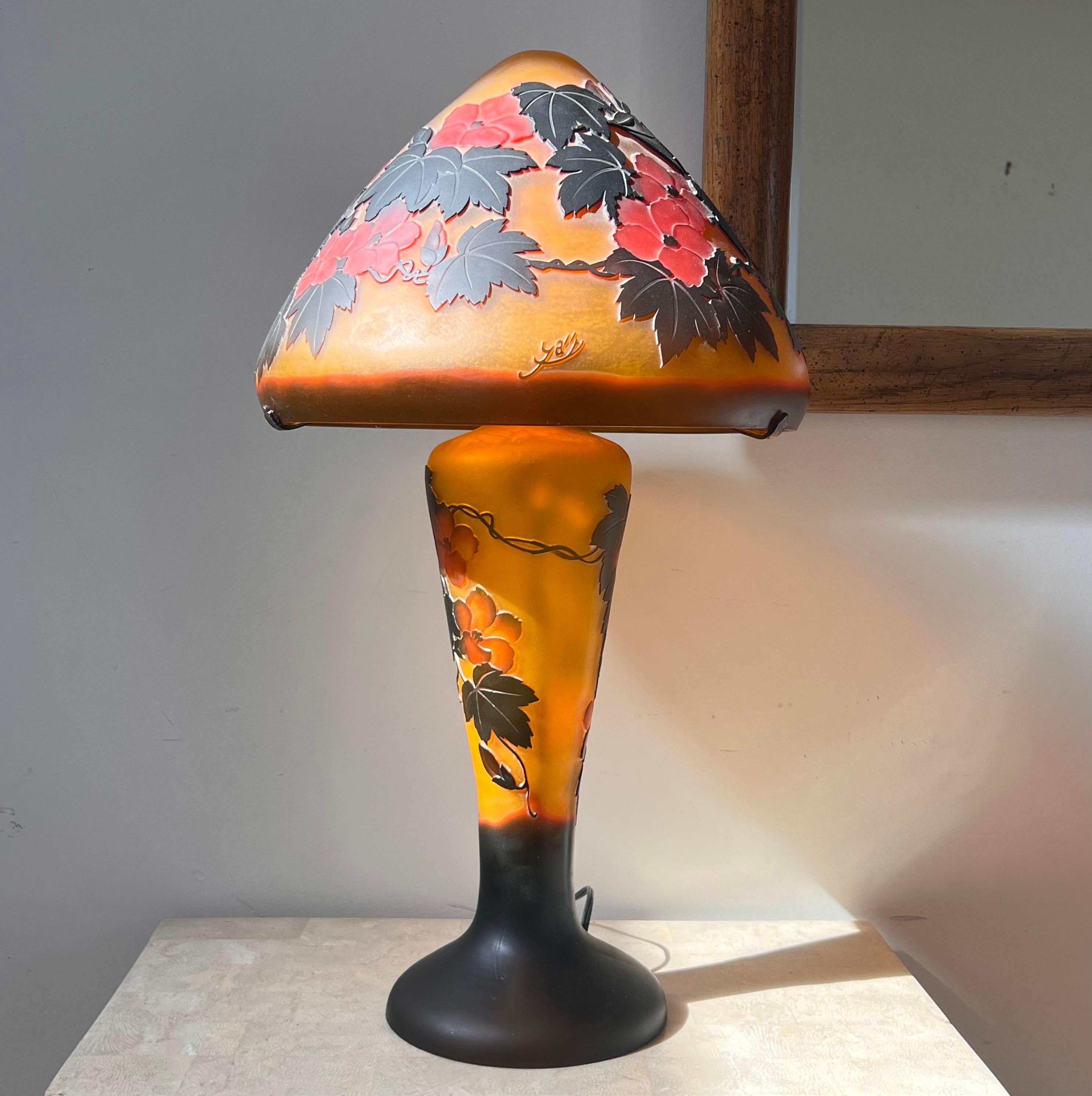 An Art Nouveau French Cameo glass table lamp after Émile Gallé, circa 1975. Signed at the edge of the shade. Autumnal shades of mandarin, pewter, and pomegranate, and in fabulous working condition. This is an authorized authentic reproduction of the