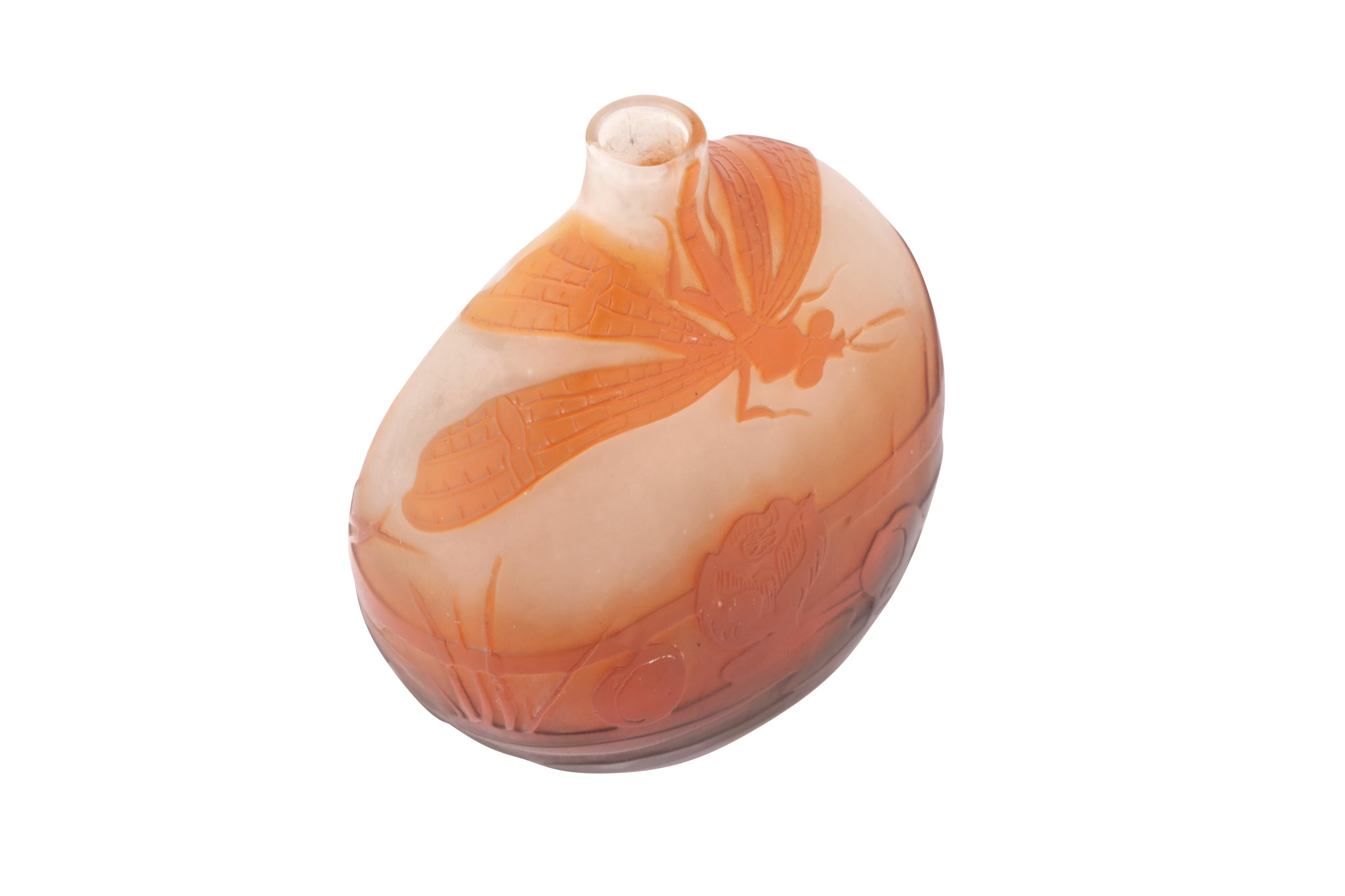 A cameo glass waterlillies and dragonfly vase, of gourd-shaped form, overlaid and acid-etched with a pond landscape scene in tones of amber, signed 'Gallé' in cameo. The glass is warm and glows in the light.

Émile Gallé was a French artist and