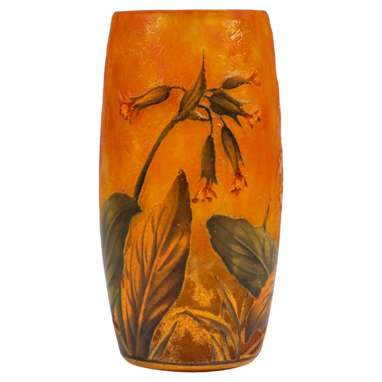 Cylindrical vase, colorless glass with flaky yellow and reddish orange powder melts, with etched cowslips decoration painted in colored enamel, satined surface in the background and inside, painted signature 'DAUM NANCY FRANCE' with the cross of