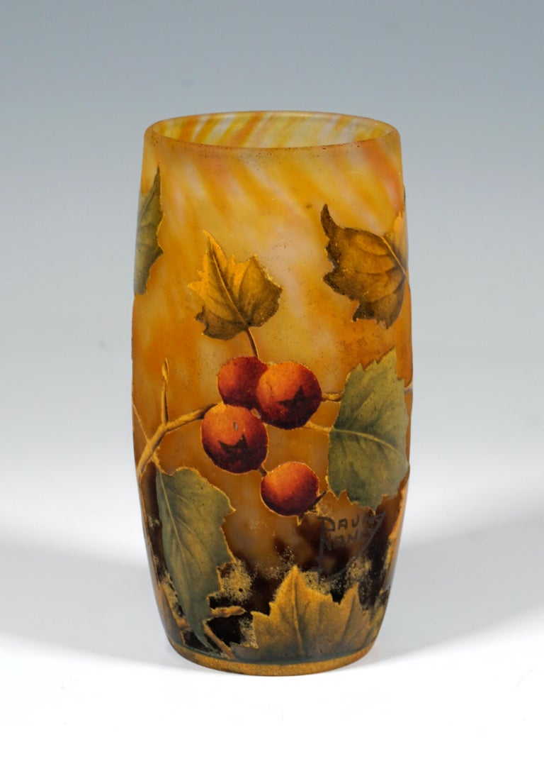 Cylindrical vase, colorless glass with flaky white, yellow and reddish, in the stand area with dark brown powder melts, with etched rose hip decoration painted in colored enamel, satined surface in the background and inside, relief signature 'DAUM