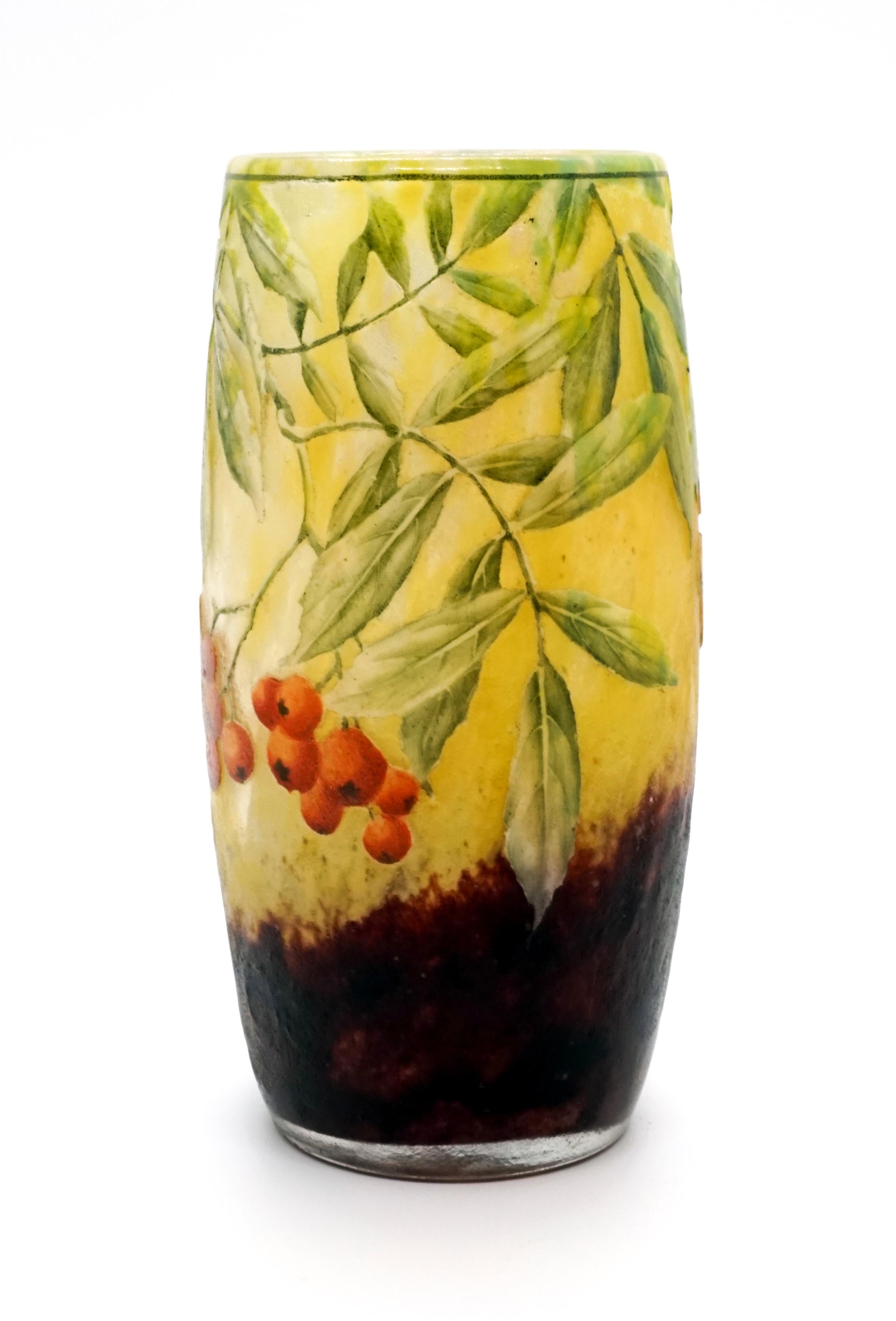 Cylindrical vase, colorless glass with flaky yellow and white, in the stand area with blackberry-colored powder melts, satined, structured surface with etched sea buckthorn decoration painted in polychrome enamel, relief signature 'Daum Nancy' with