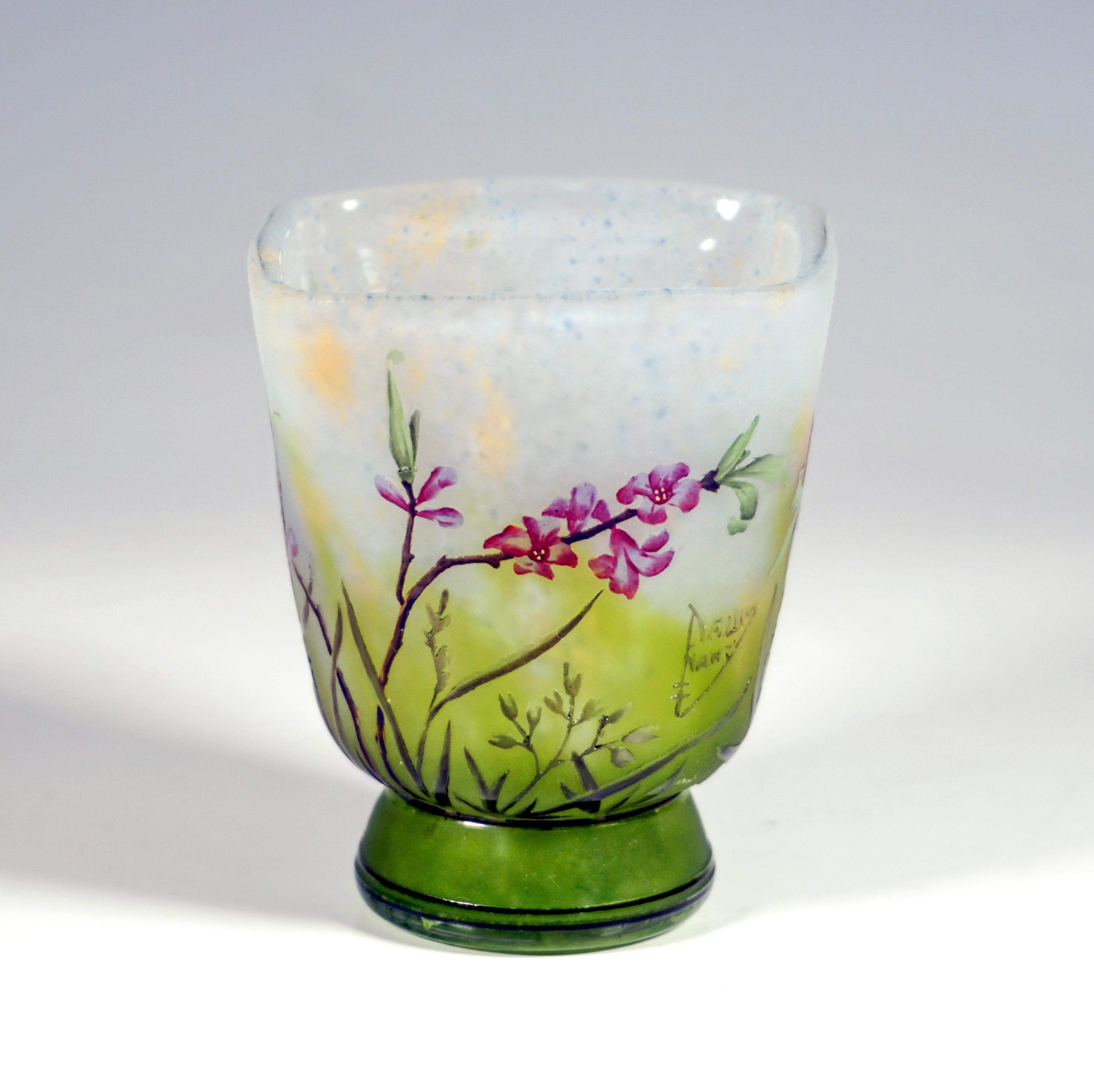 Beaker-shaped vase on a stepped, conical base, widening upwards to a square mouth rim, colorless glass with flaky white, yellow and blue, in the base area with green colored powder inclusions, with etched and painted in colored enamel Daphne decor,