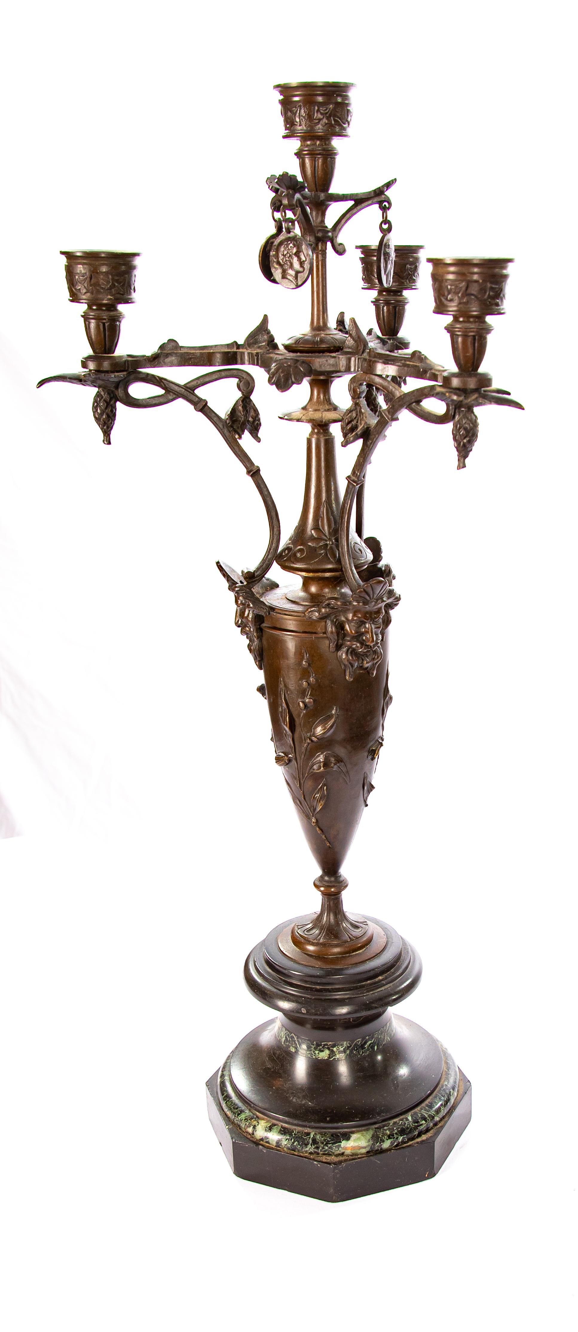 Offering this magnificent pair of art nouveau candelabras. Starting on a base that is hand painted to look like marble. It rises to a foliate spacer then the main body has floral details. Around the body at the top is three heads. From there it tops