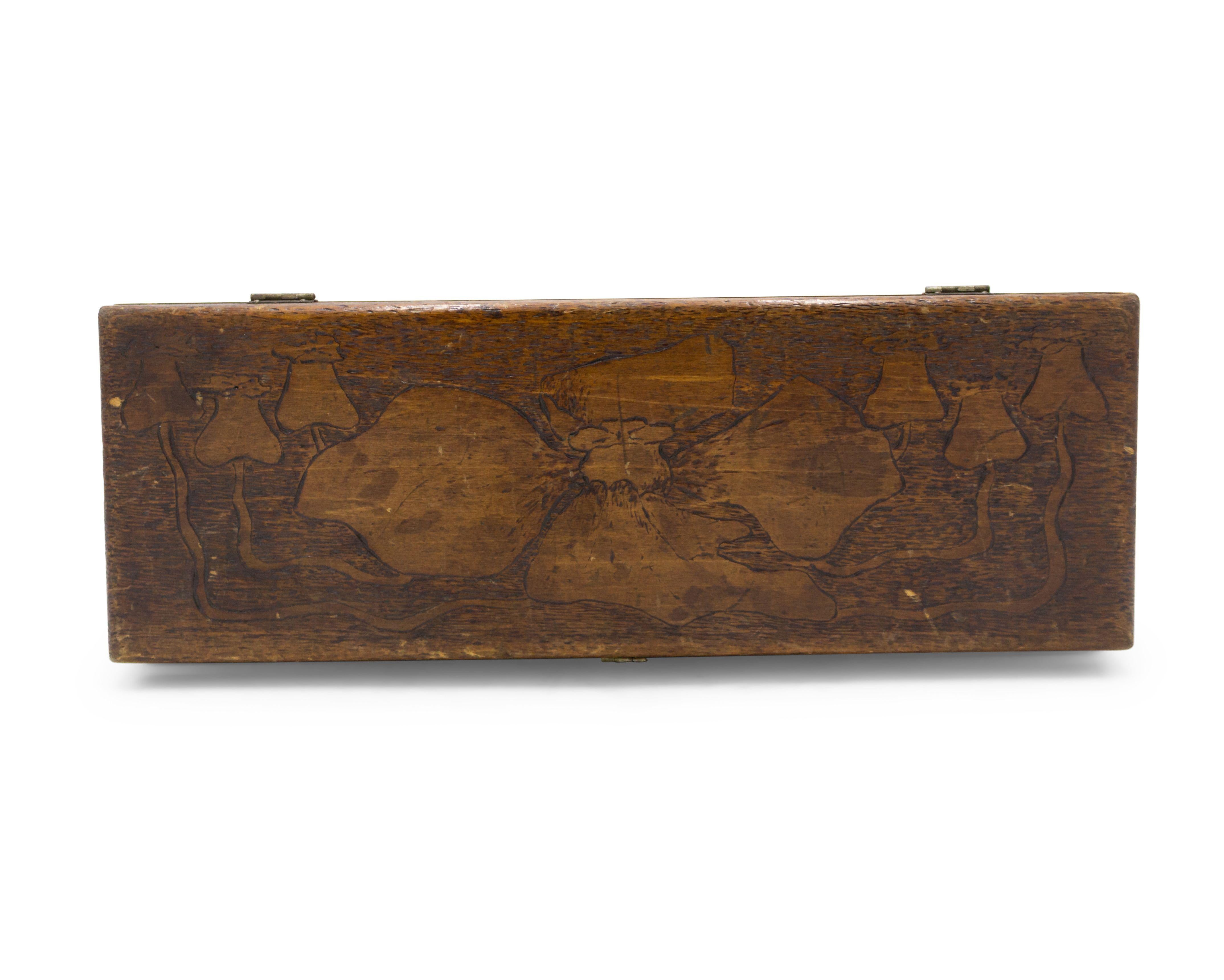 Boîte de forme oblongue en bois Art Nouveau avec un motif floral gravé.
 