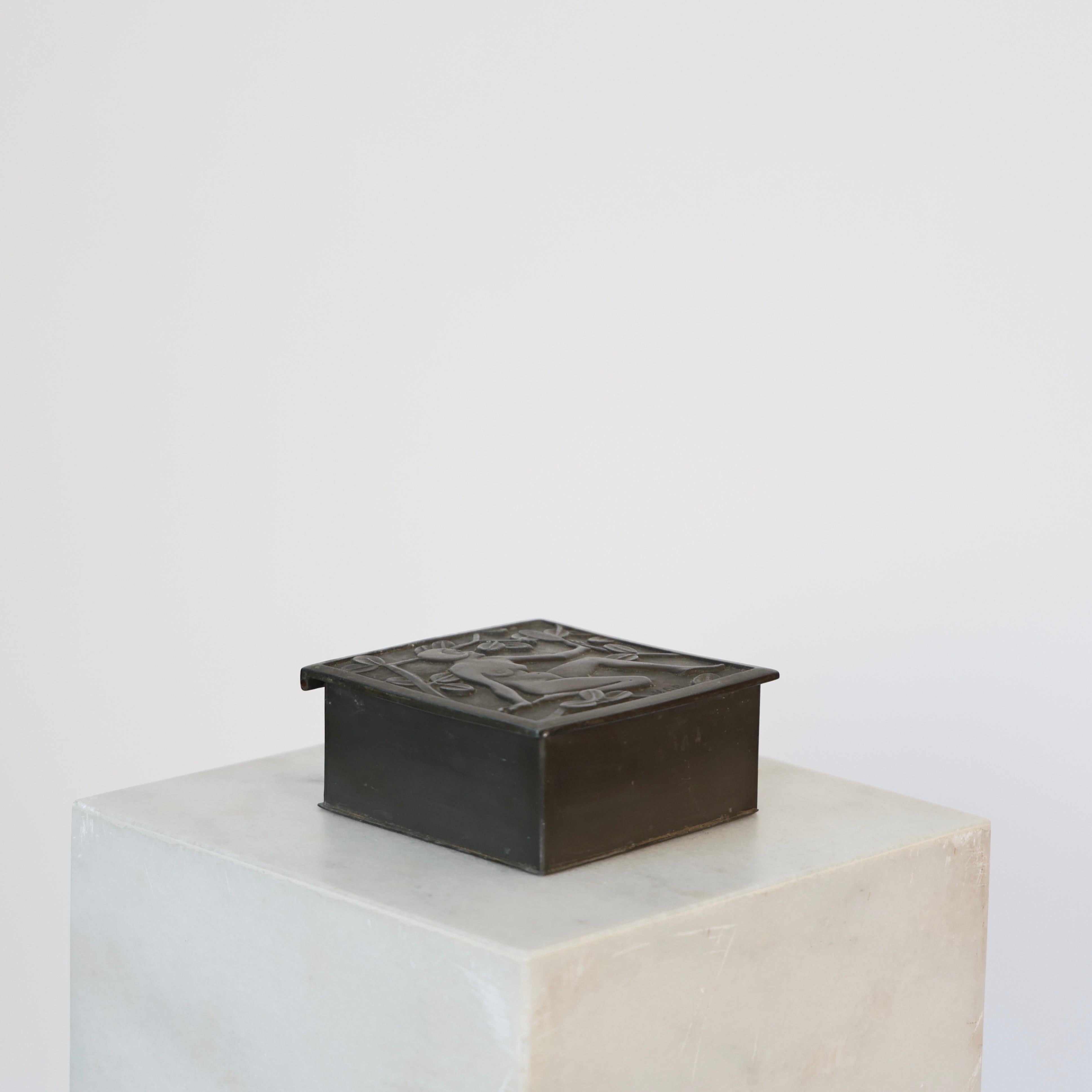 Elegant Art Noveau Casket made by Niels Dam Ravn in the later 1920s.

* Lidded metal casket with a woman and plants on the lit. Velvet inner box. Signed NDR lower right on the lid.
* Designer: Niels Dam Ravn.
* Year: est. late 1920s (prior to