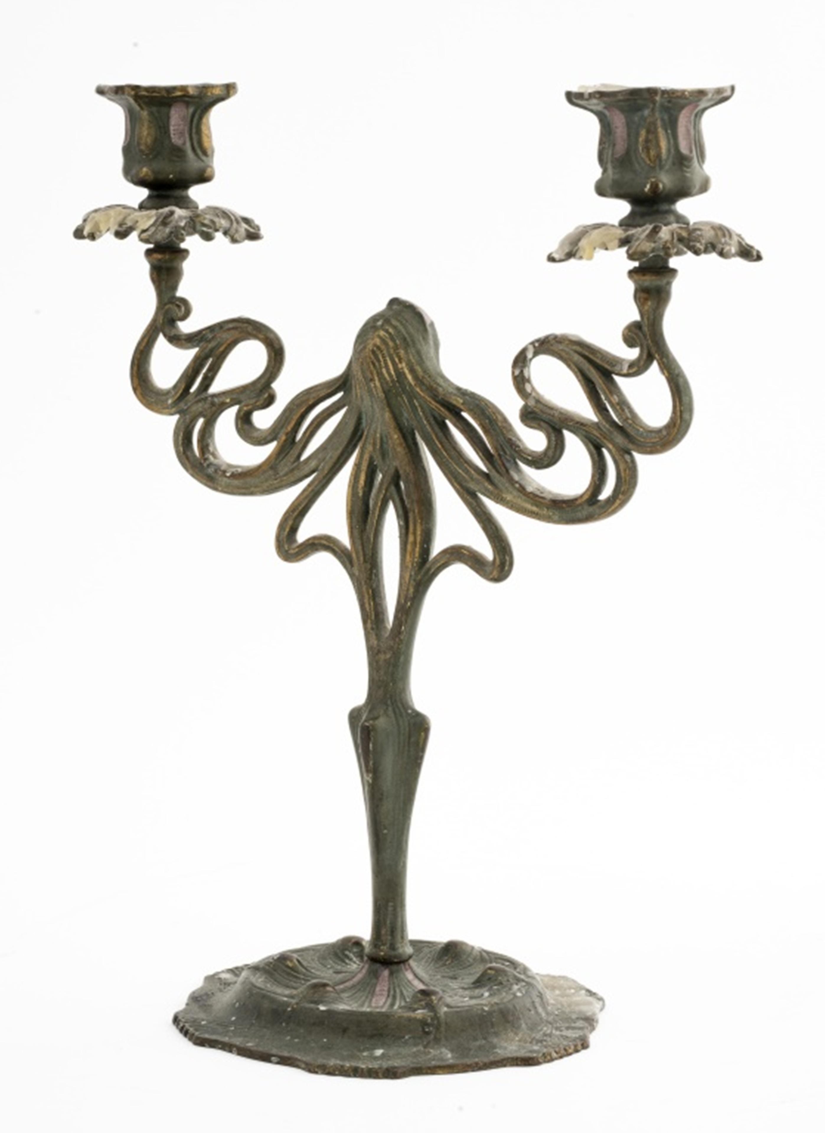 Art Nouveau candelabra in patinated cast iron, the stem depicting a sensuous female head with long flowing hair strands holding up two candle sockets. 12