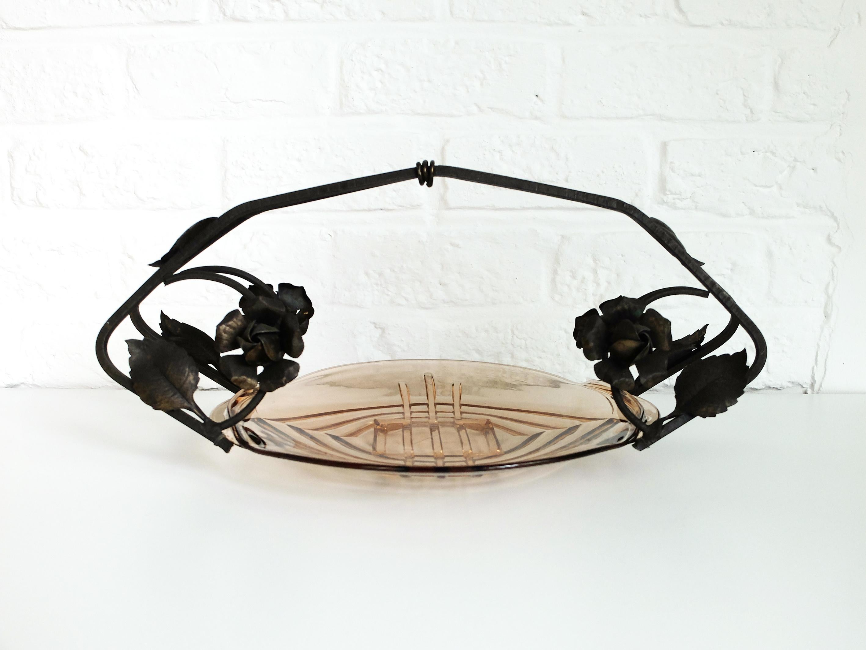 Centrotavola o ciotola di presentazione in stile Art Nouveau ceco.

Struttura e fiori in metallo forgiato. Ciotola in vetro colorato rosa antico con motivo geometrico. 

Firmato 