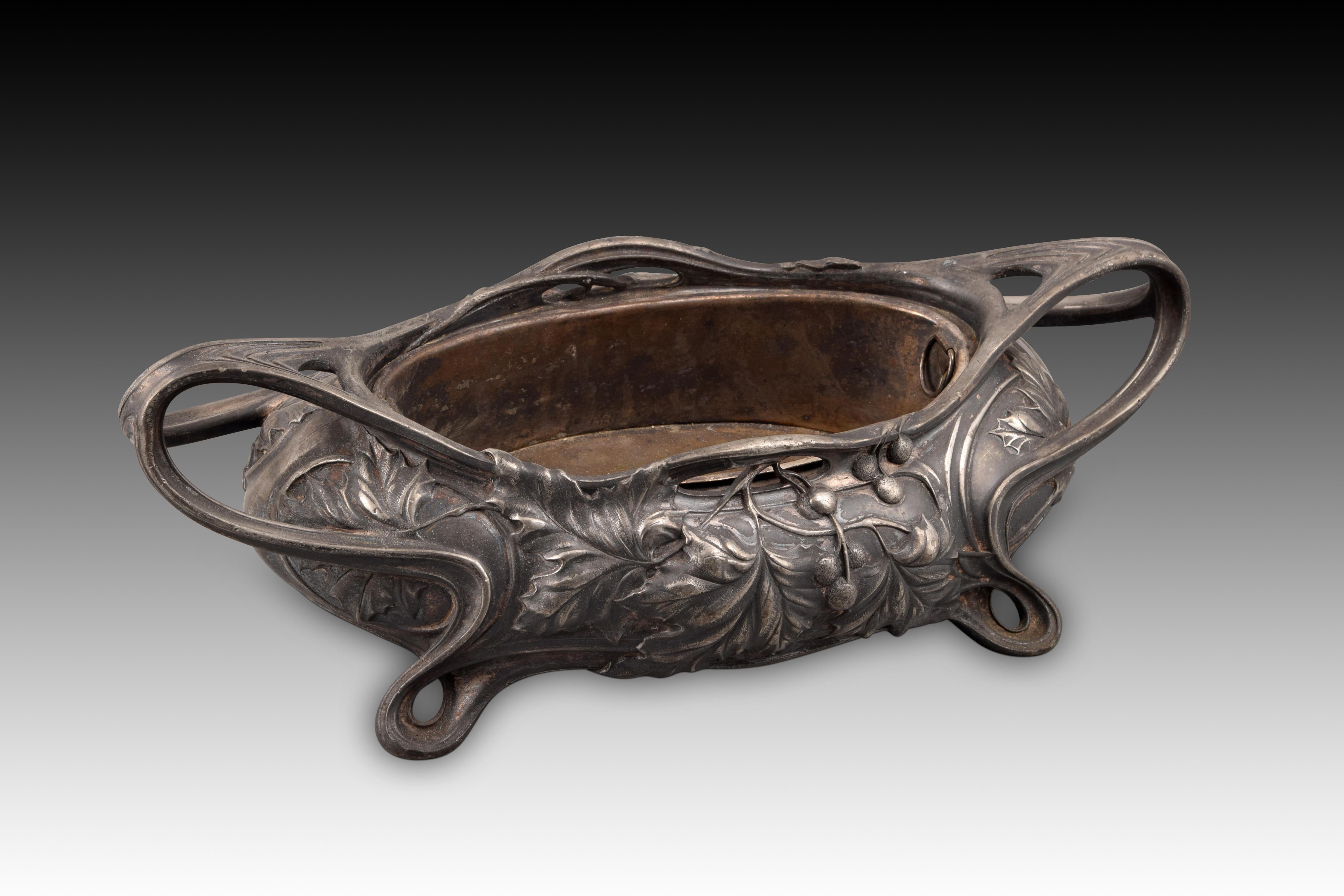 Table center or planter. Tin, metal. Víctor Saglier, towards the end of the 19th century. 
With marks on the base.
 Oval centerpiece with interior tray with handles, decorated on the outside with a fine relief based on moldings in curved lines
