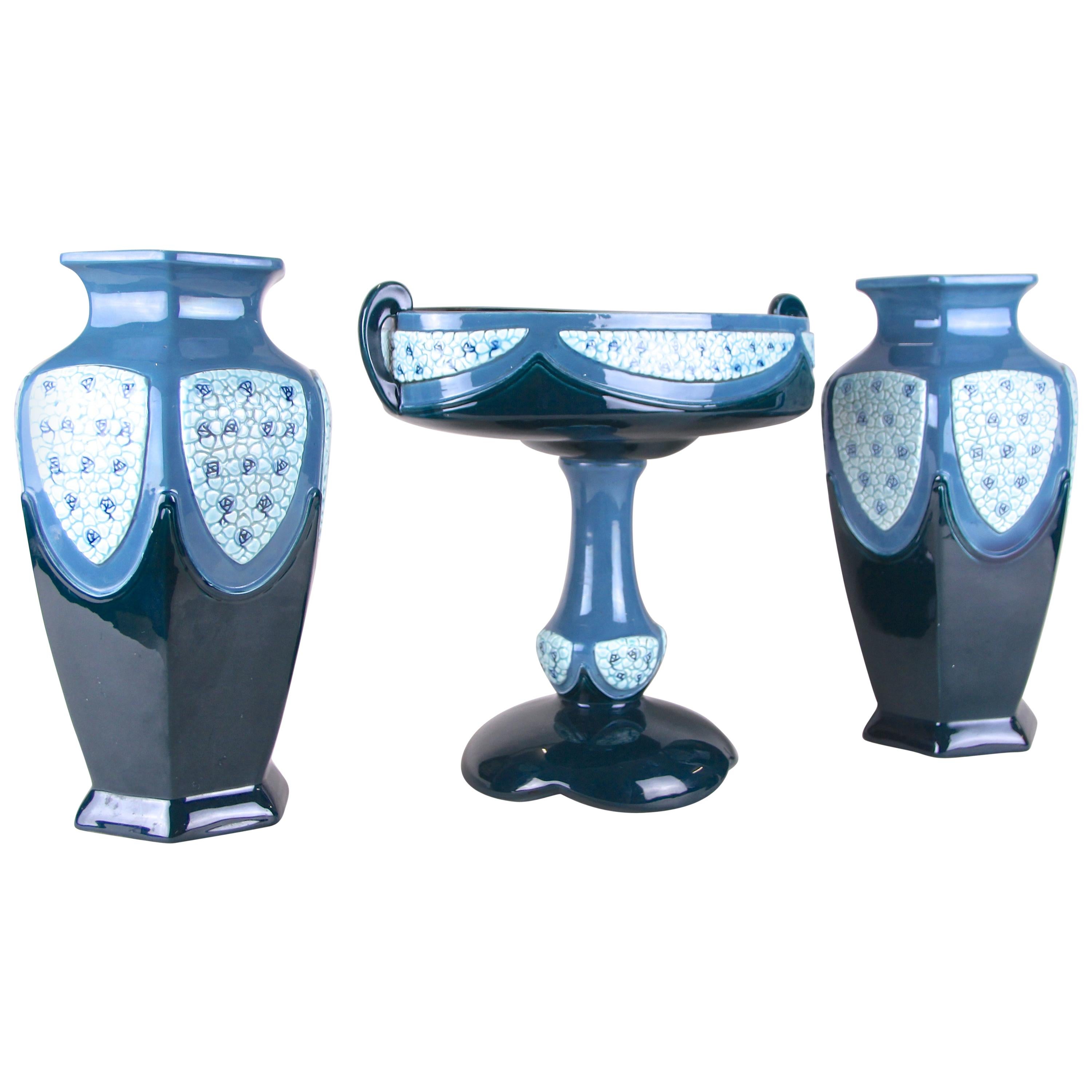 Remarkable Art Nouveau ceramic garniture/ set of vases made by the famous manufactory of Eichwald in Bohemia (former Austria), circa 1915. This representative ceramic set of three consists of two large beautiful designed vases and a suitable