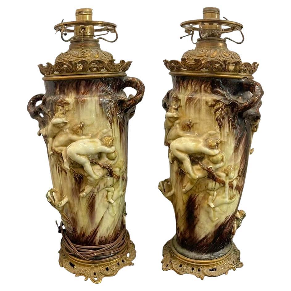 Zwei Tischlampen aus Keramik des 19. Jahrhunderts, entworfen von Theodore Deck und Gustave Cheret, mit vergoldeten Bronzebeschlägen, die spielende Kinder zwischen Zweigen und Fröschen darstellen.  Ursprünglich für Öl gedacht, später wurden