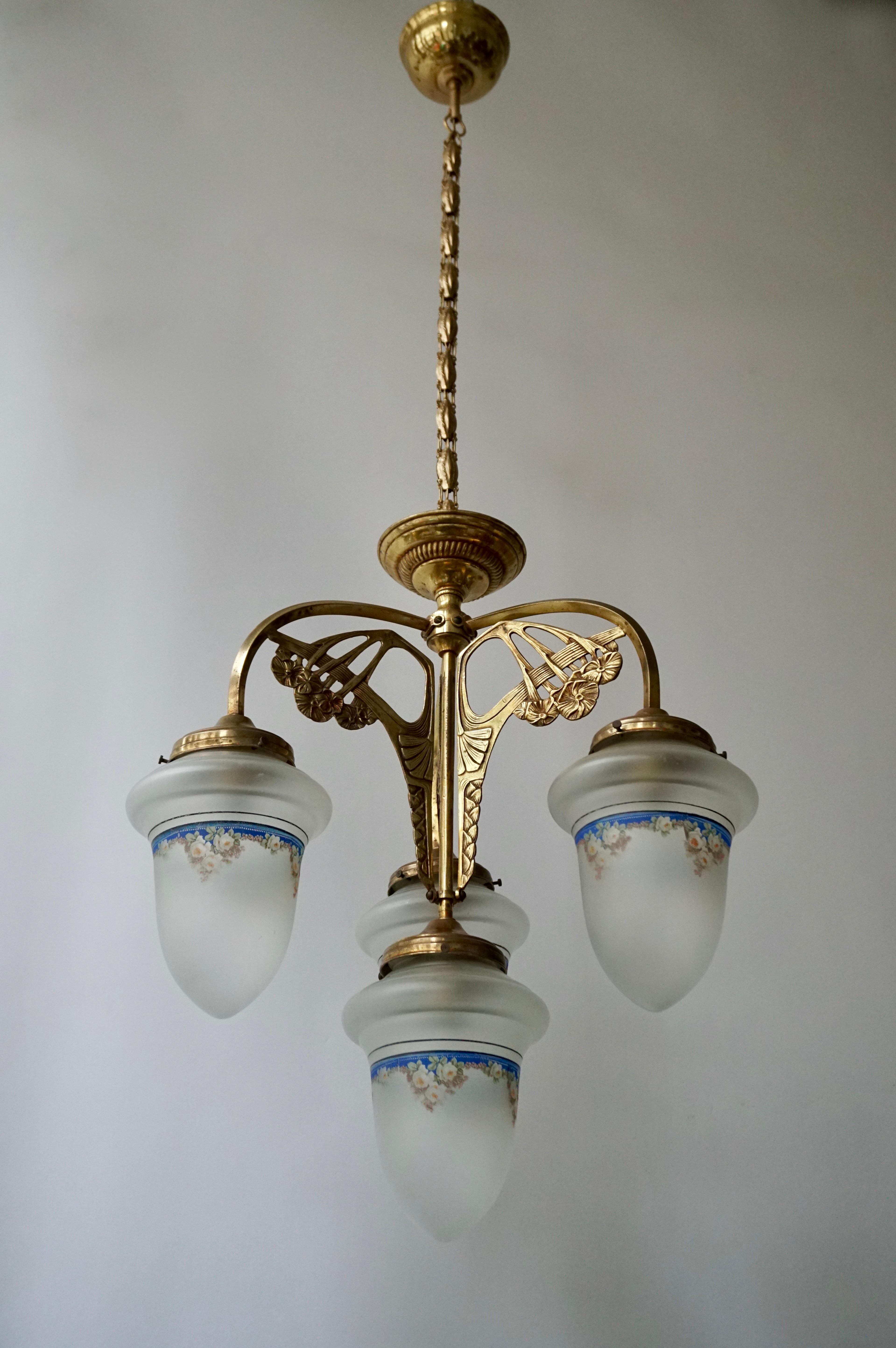Elegant Italian brass Art Nouveau chandelier with four painted glass shades.
Measures: Diameter40 cm.
Height fixture 50 cm.
Total height including chain 110 cm.