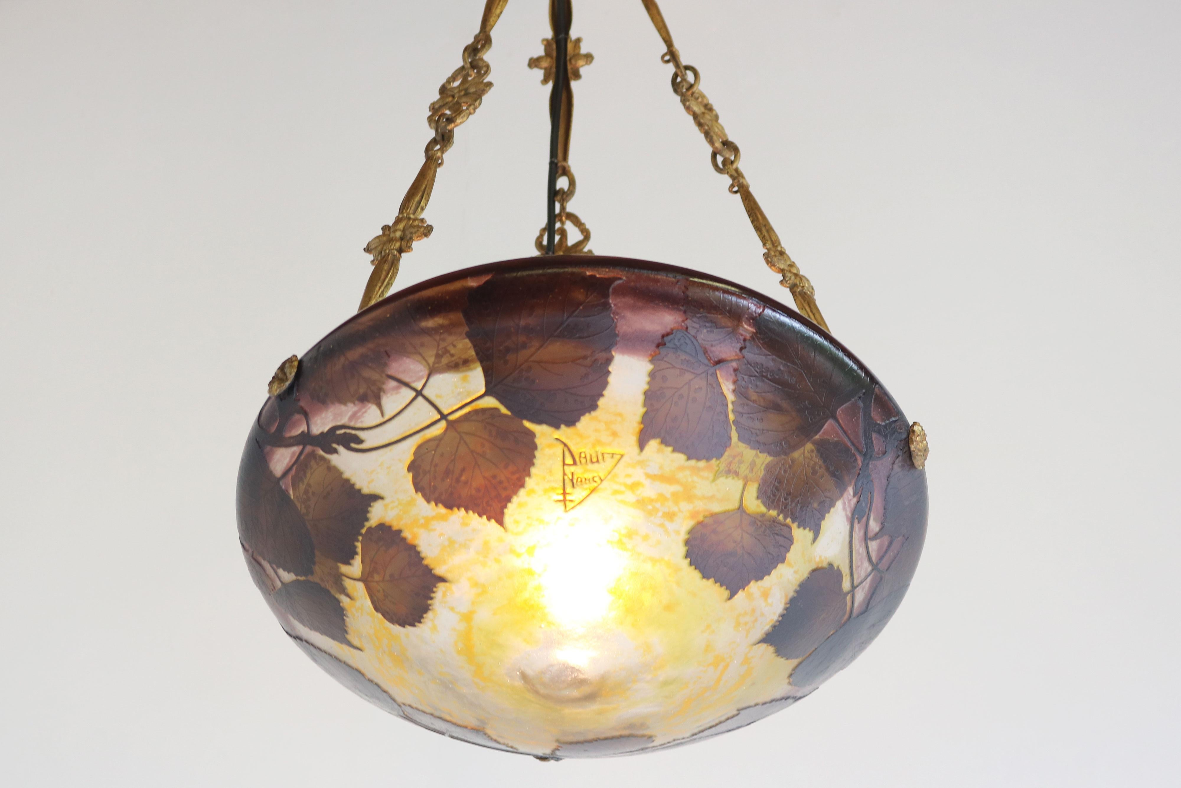 Embrace the beauty of the Art Nouveau era with this exquisite DAUM Nancy chandelier! 
Crafted in 1910 and signed with the ''Daum Nancy cross the Lorraine'' signature, this stunning piece features delicately etched poplar leaves in rich shades of