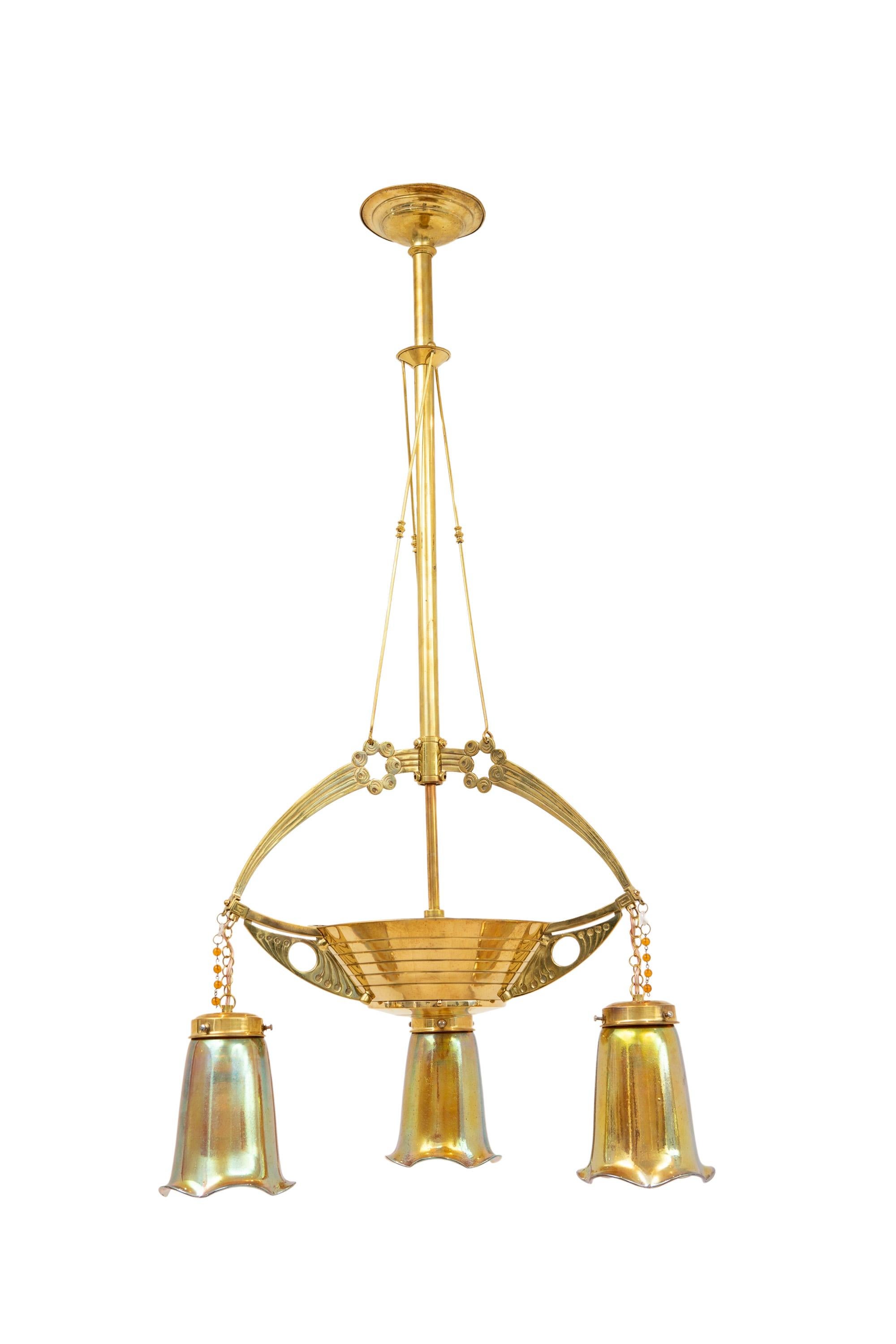 En Viena, hacia 1900, se podía encontrar tanto el Art Nouveau estrictamente geométrico como el floral de influencia francesa. 
Esta pieza demuestra las distintas formas en que puede utilizarse el vidrio. Tres elementos dispuestos cuelgan de una