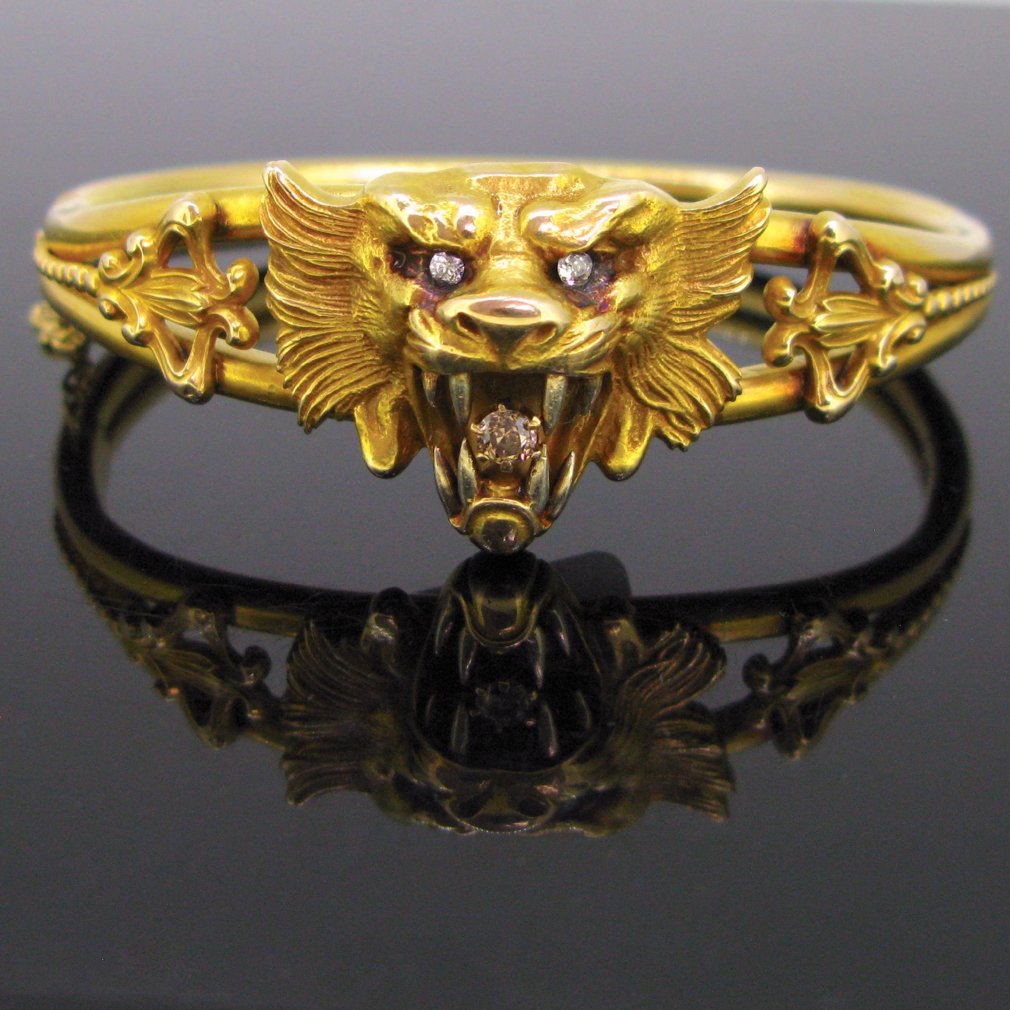 Comments: This stunning bangle is from the Art Nouveau era. It features a fierce chimera / lion holding a diamond in his jaws. The eyes are set with old mine cut diamonds. The shoulders of the bracelet are nicely adorned with leaves and beads