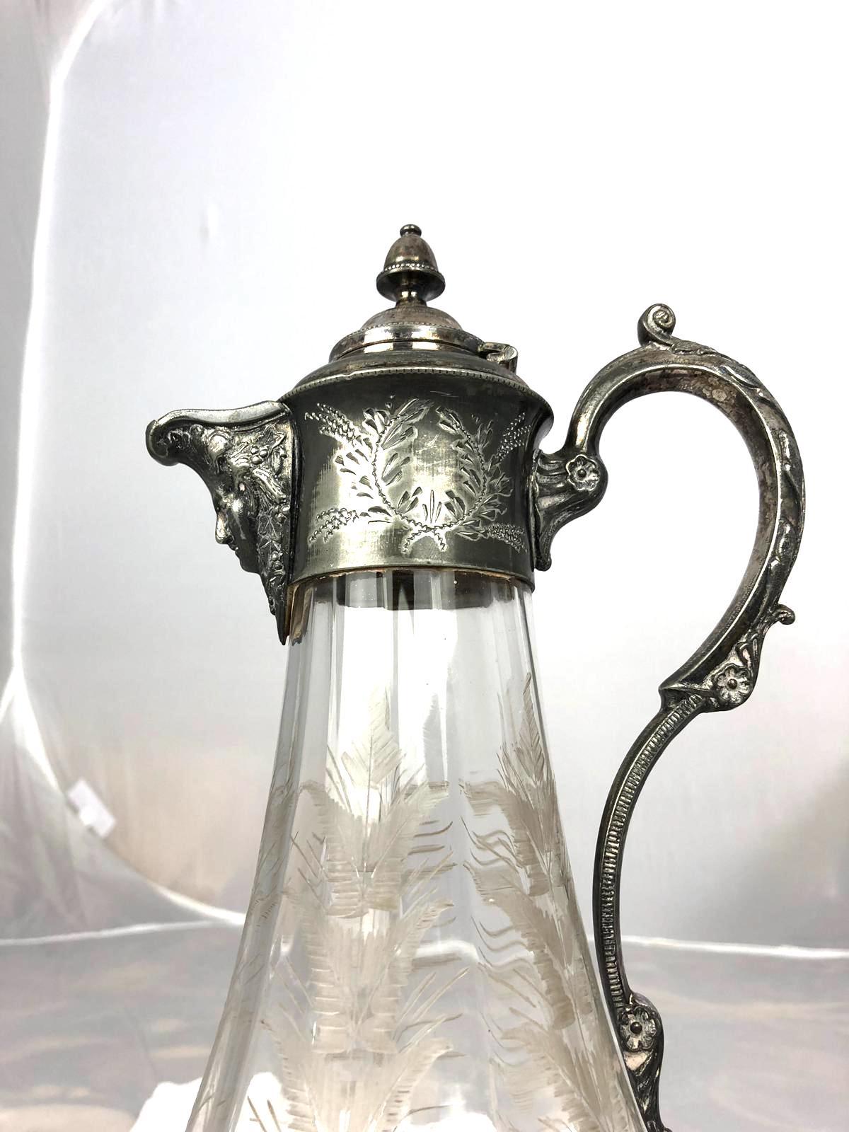 A stunning 19th century Art Nouveau claret jug which has the function for holding red wine and water. The jug has silver plated mountings: Spout, lid and handle which are stunningly ornamented with chiselled decorations consisting of scrolls,