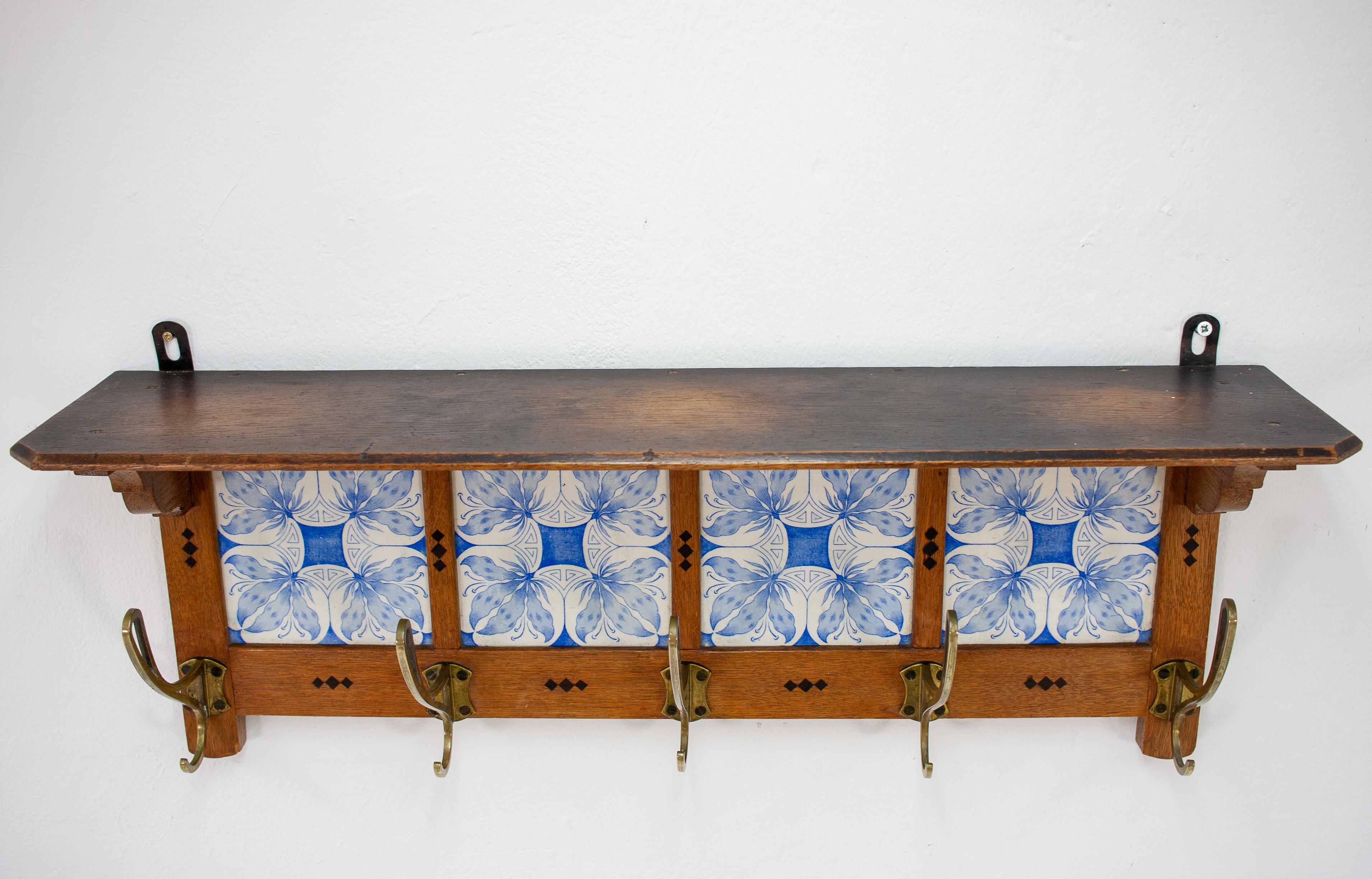 Art Nouveau wall coatrack in solid oak with the original tile inlays and five graceful brass hooks. Dutch, 1925.