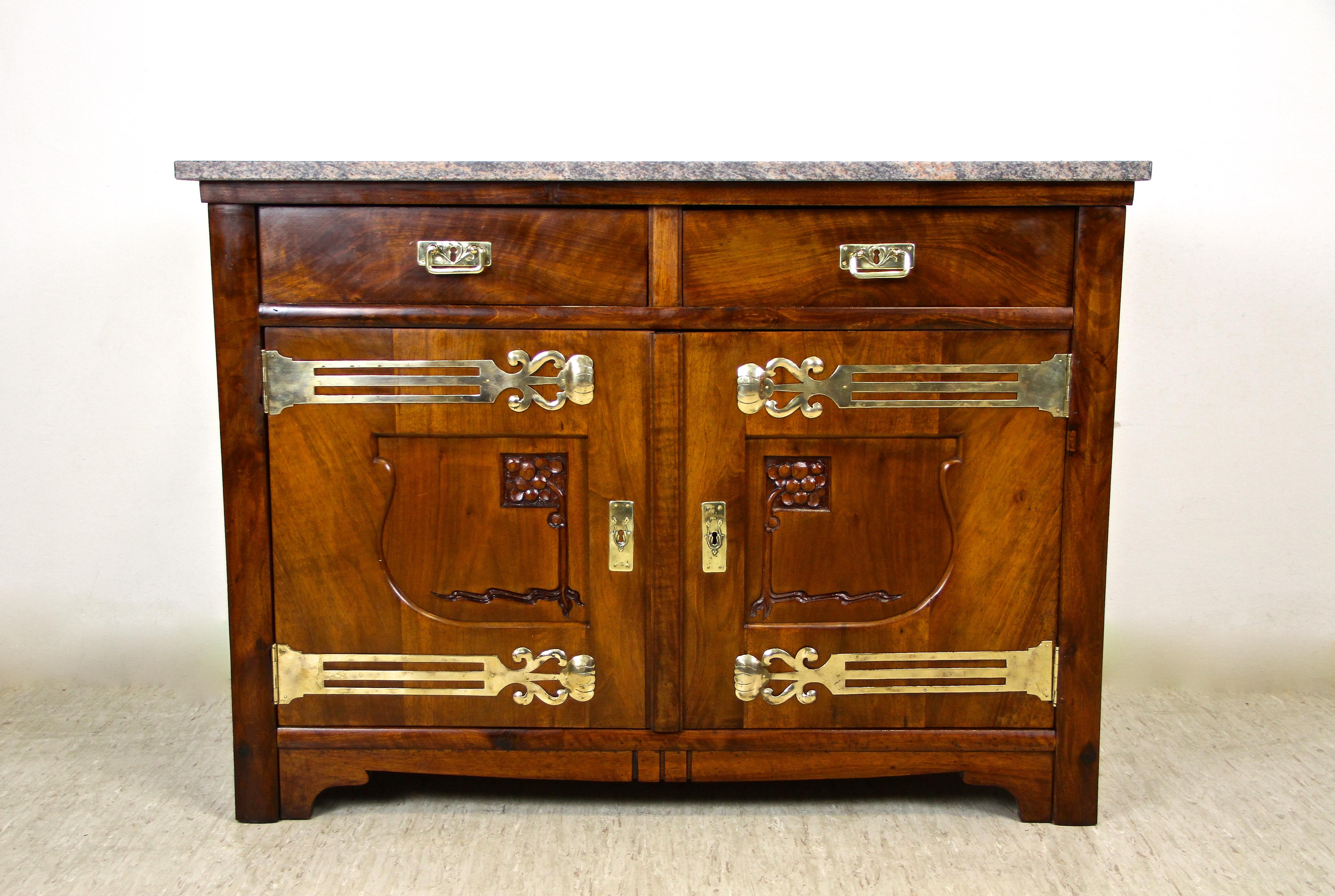 Lovely Art Nouveau Nutwood commode/ dresser from the beginning of the 20th century in Austria. Made around 1905, this eye-catching piece of a commode is adorned by fantastic brass applications. The doors can be wide opened and are decorated by