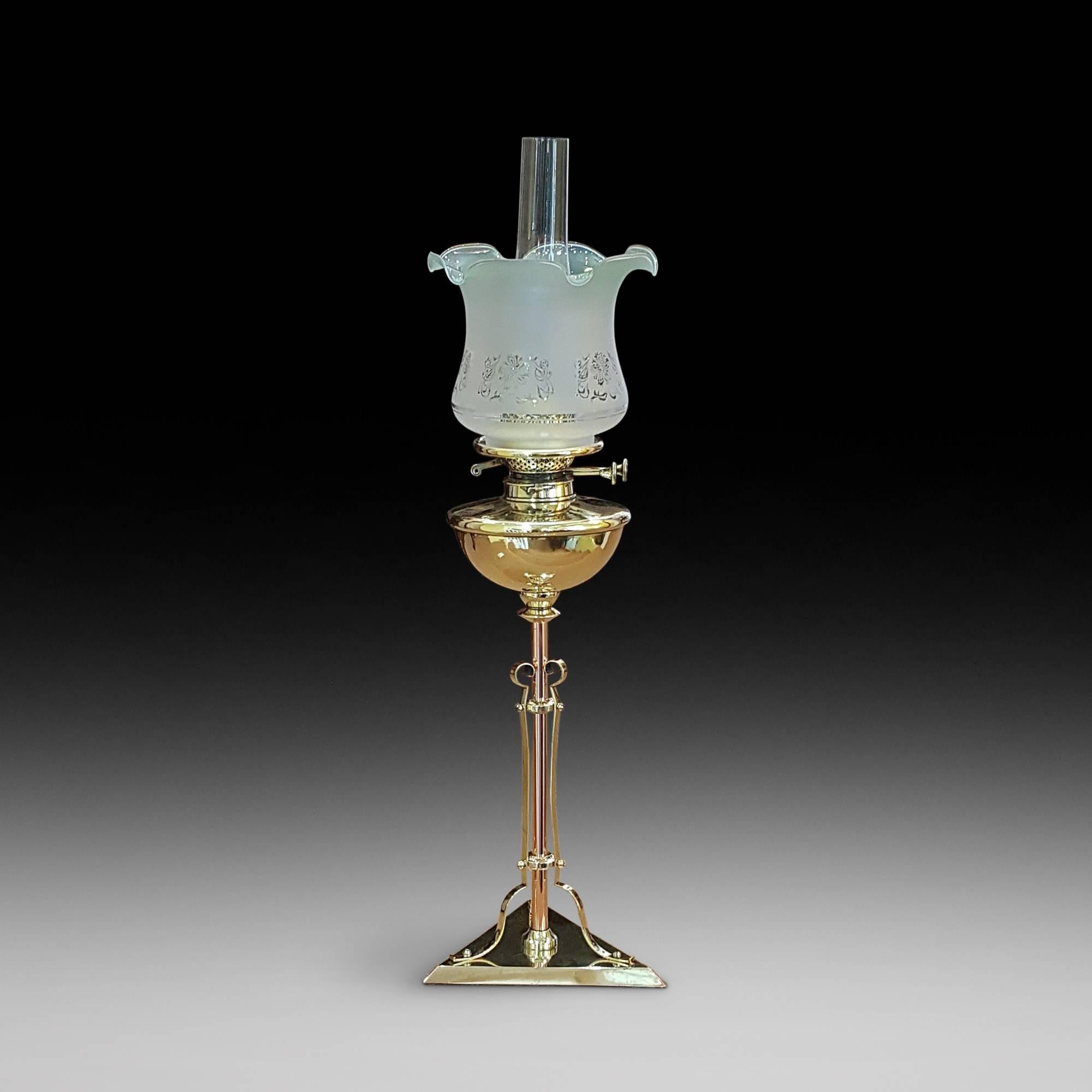 An Art Nouveau copper and brass oil lamp on triangular base extending to a central stem with domed oil receptacle with frosted glass shade and chimney - a platform has been added for a battery operated LED light.
Measures: 29