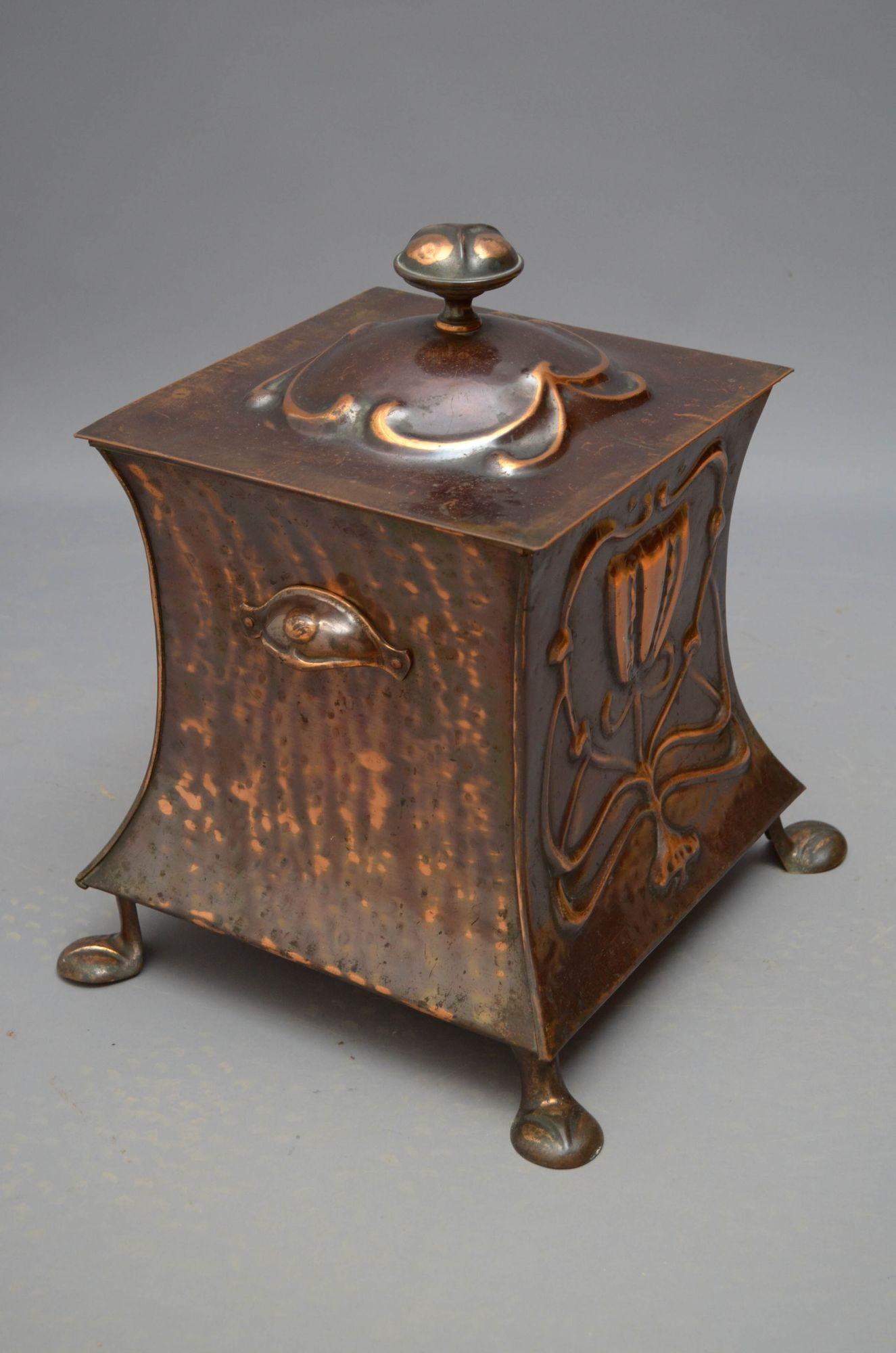 Sn5337 Stylish Art Nouveau copper coal bin with, having scroll embossed lid enclosing a liner, two carrying handles, decorative design to the front and pad feet. This antique coal bin is in home ready condition. c1900
H17.5