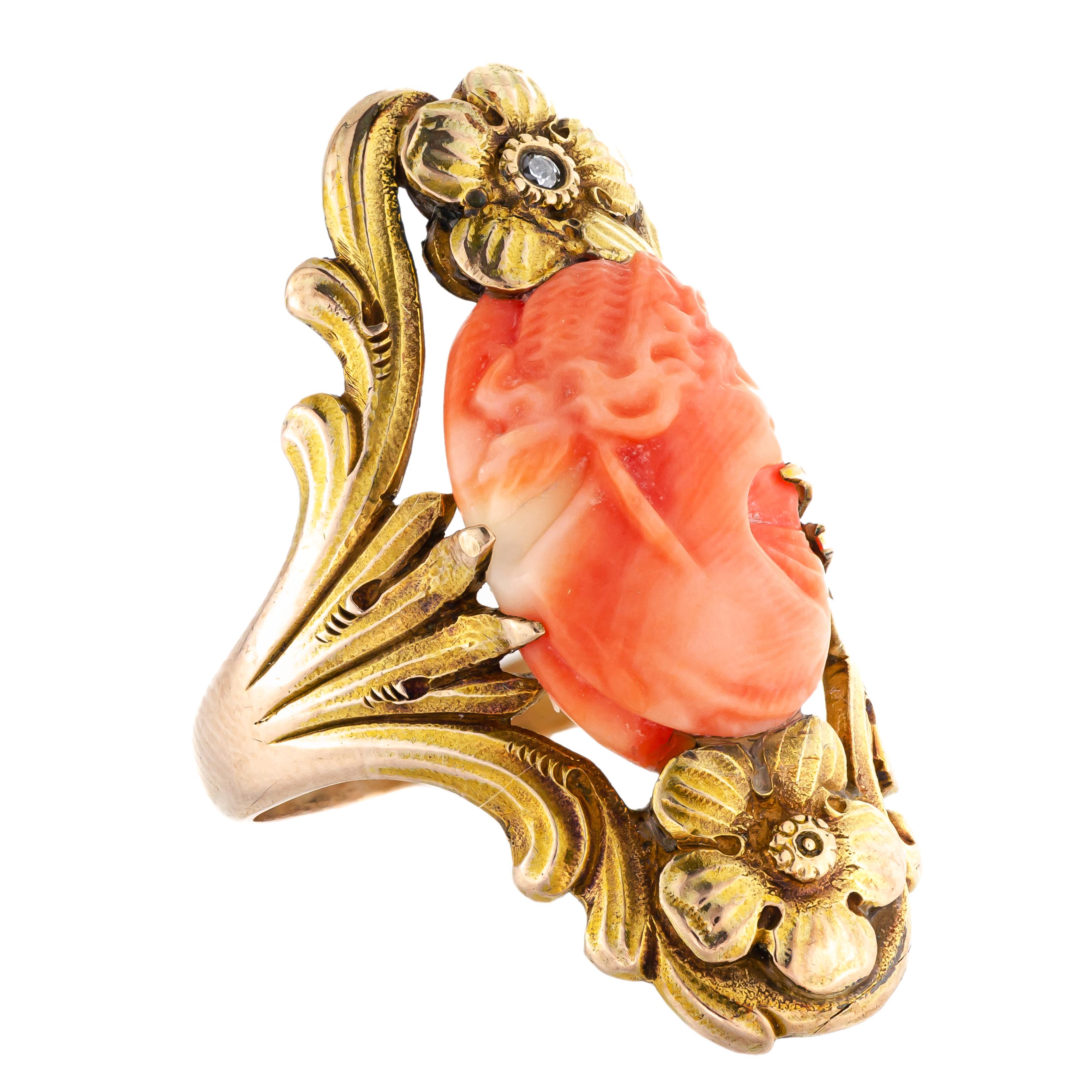 This is a magnificent Art Nouveau coral cameo from 1905 that is sure to captivate anyone who lays eyes on it. The beautifully carved bust of a woman in profile is elegantly set in an elaborate 14kt yellow gold ring mount, which features a stunning