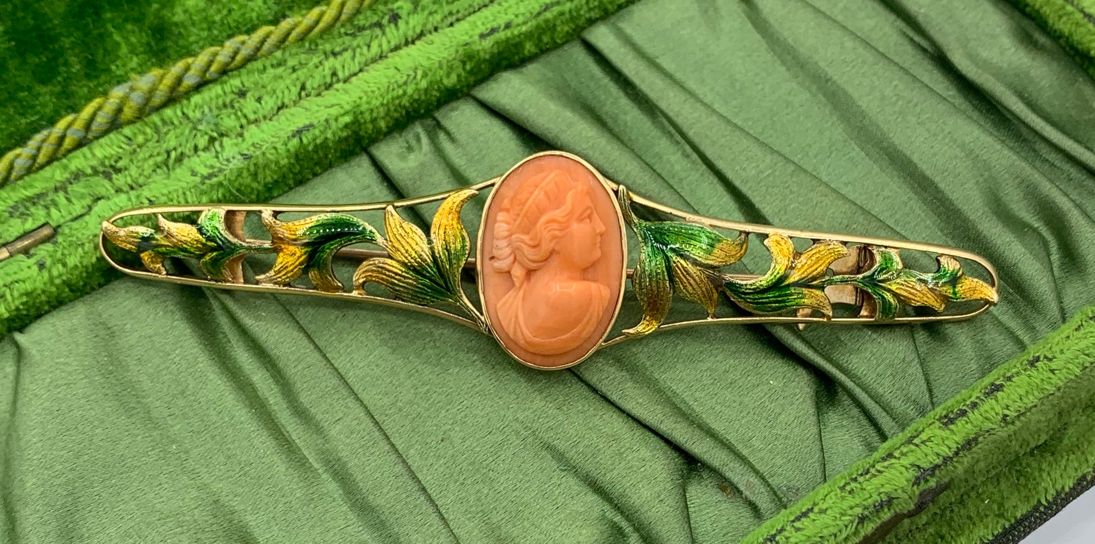 This is an absolutely stunning antique Art Nouveau - Belle Epoque Coral Cameo Brooch Bar Pin with Enamel Flower and Leaf Design in 14 Karat Gold in a monumental four inch length.  The Coral Cameo is exquisite with a high relief carving of a