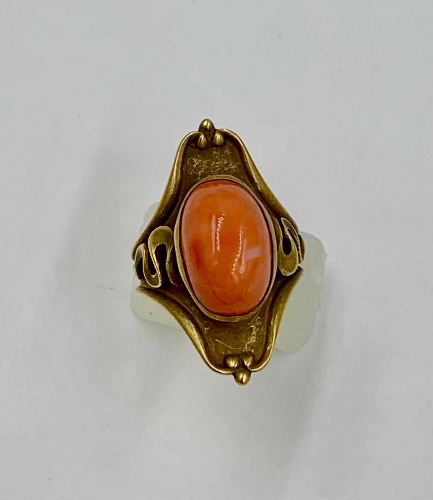 Si tratta di un magnifico anello originale in stile Art Nouveau con un bellissimo cabochon di corallo salmone naturale incastonato in uno splendido design Art Nouveau in oro 14 carati.  L'anello è un capolavoro del periodo Art Nouveau.  Questo