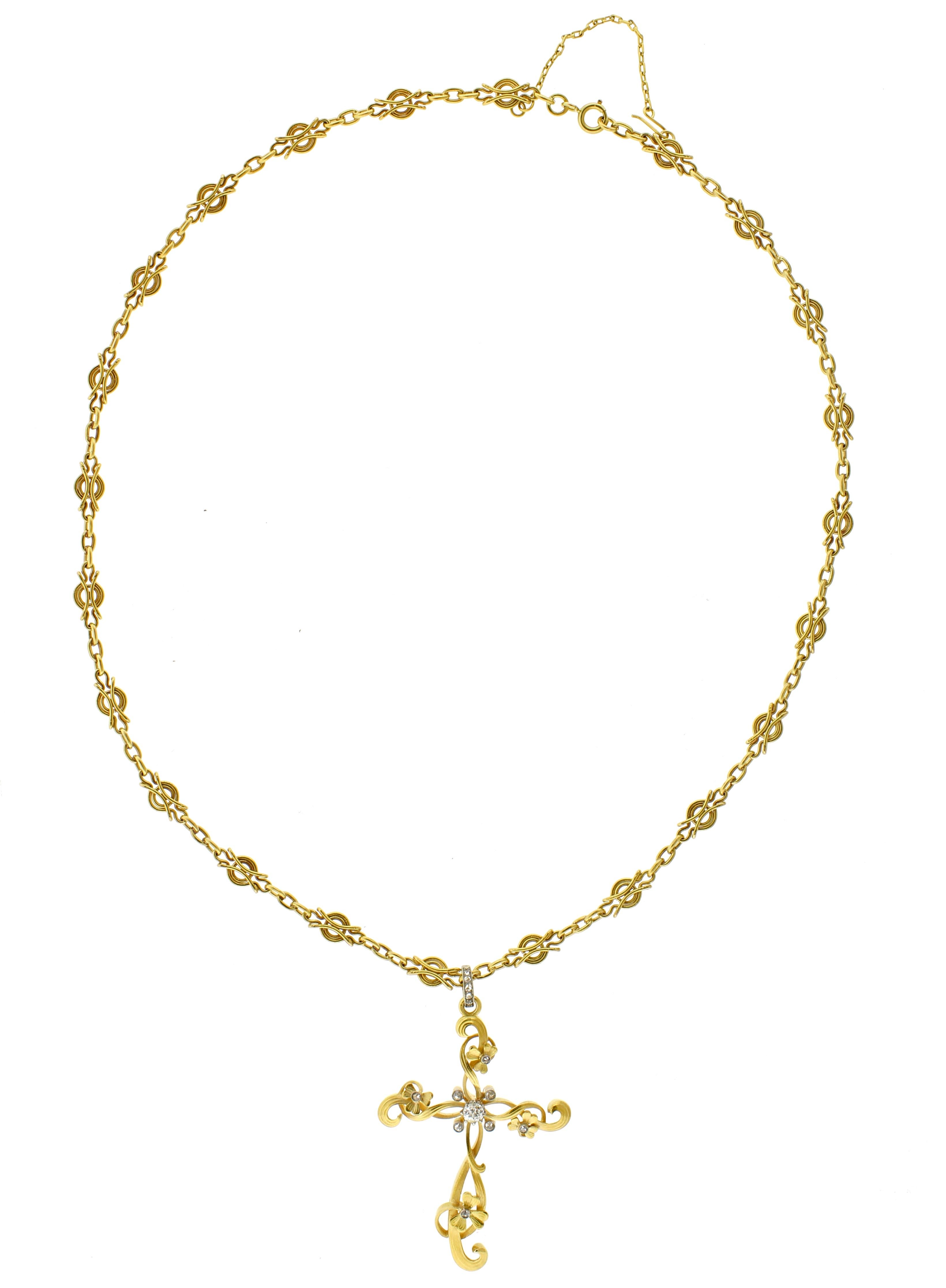 This handcrafted 21-inch chain features a bail adorned with five rose-cut diamonds, totaling approximately 0.05 carats. The 2.25-inch cross pendant, designed in the Art Nouveau style, showcases a beautifully intricate twisted flower motif. At its