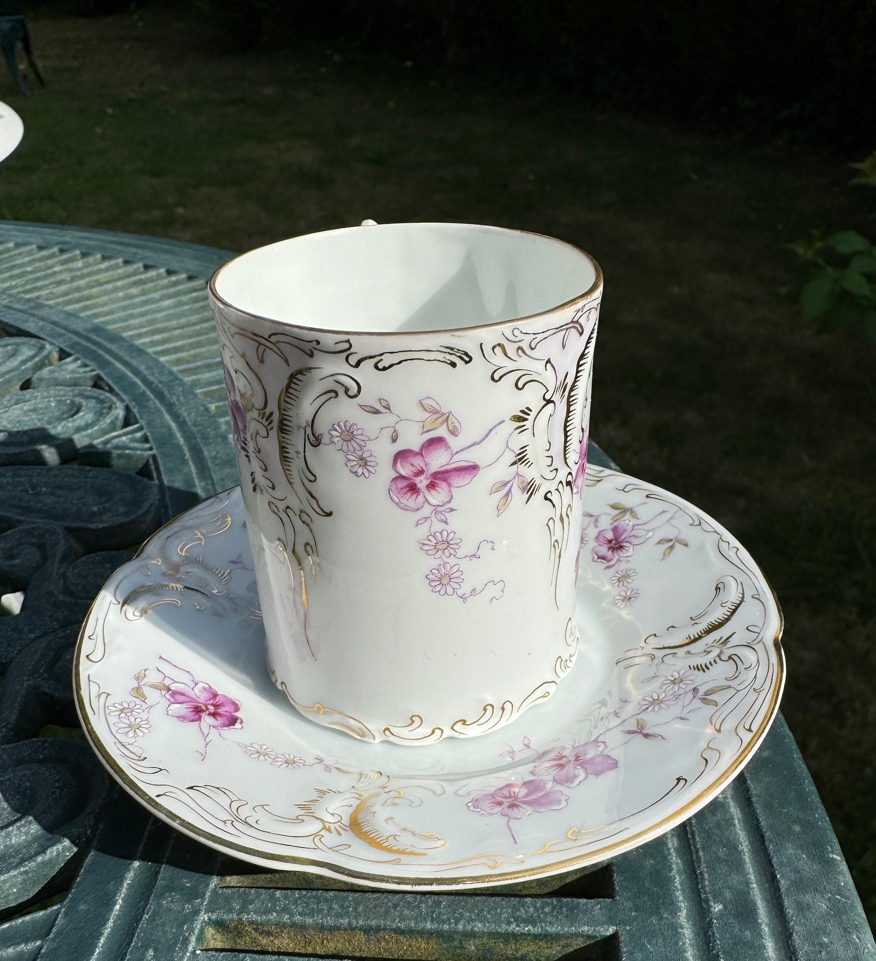 Taza y Plato Sanssouci Dorado y morado sobre fina porcelana blanca de Philipp Rosenthal Circa 1900.

Este par de tazas y platillos del periodo Art Nouveau fabricados por Rosenthal es muy refinado. La porcelana blanca es fina e ingrávida. Su delicado